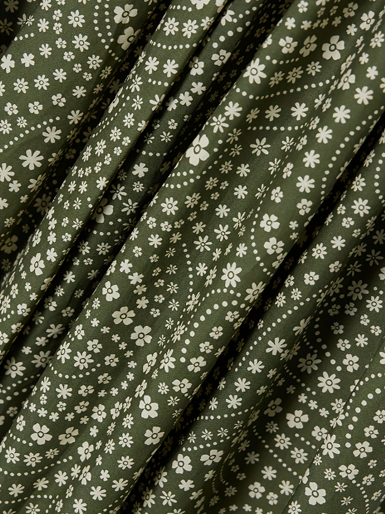 Katta o'lchamdagi ko'ylak, parallel qirqimlar va gullar bosma, organik yashil, o'rta uzunlikda.