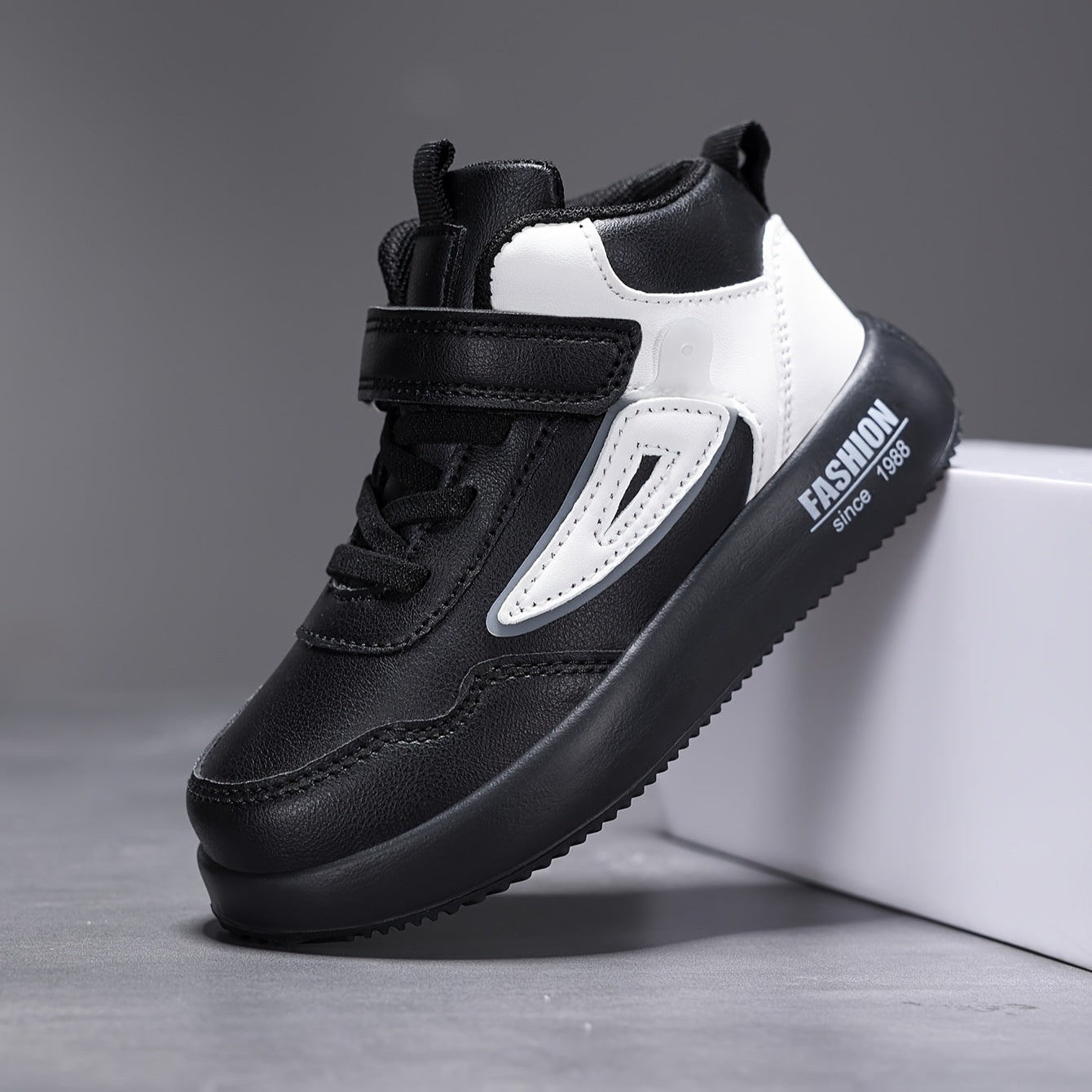 Bolalar uchun retro o'rtacha balandlikdagi krossovkalar qora va oq rangda, oson bog'lash mumkin, kundalik faoliyatlar va yugurish uchun mukammal.