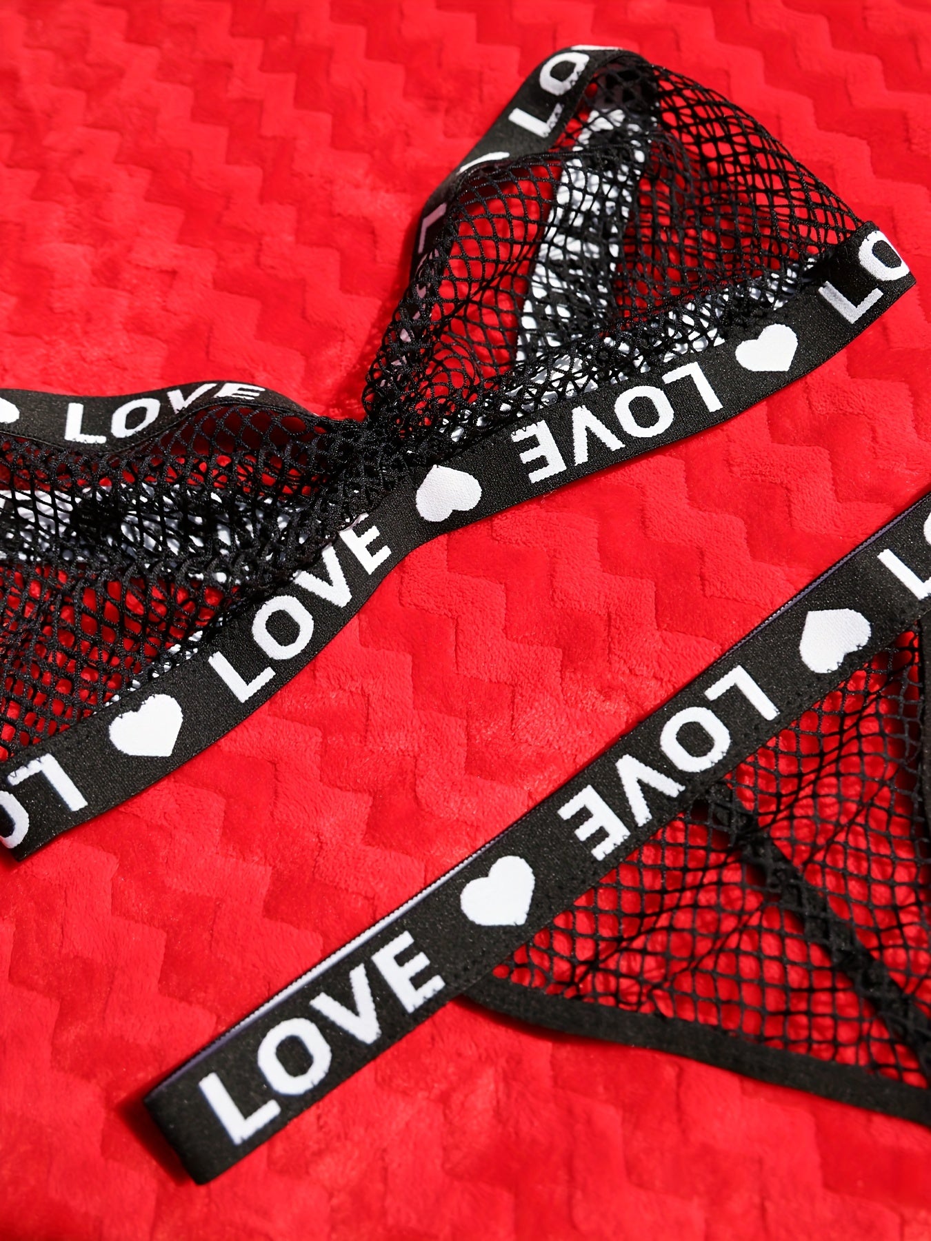 Yozuv detali bilan jasur va nafis tarmoq ichki kiyim to'plami, bandeau brassiyer va thongni o'z ichiga oladi. Elastan/polister aralashmasidan tayyorlangan, qo'l bilan yuvish mumkin.