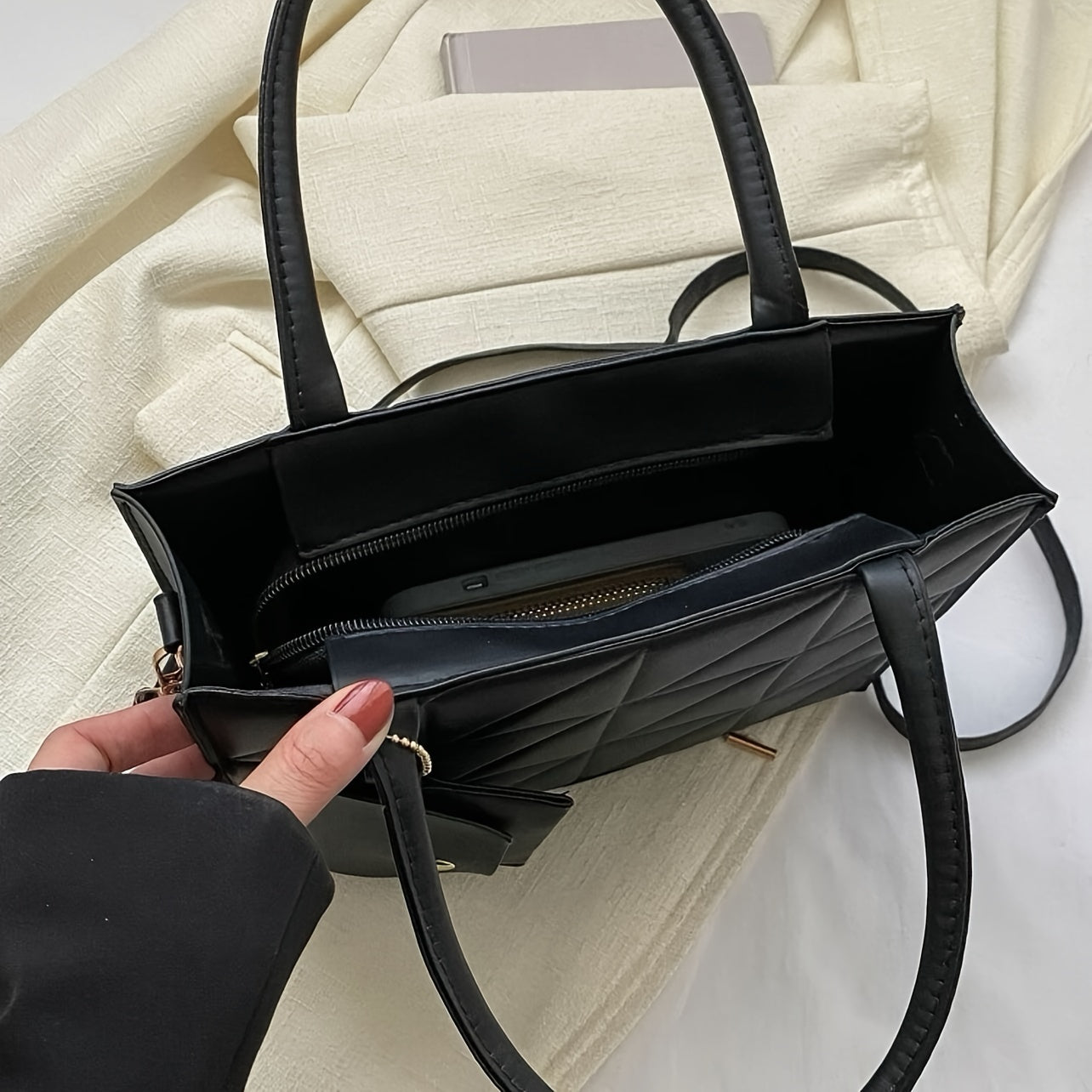 Qora qoplangan sintetik charm sumkasi, oltin detallari va ajraladigan uzun cho‘ntak bilan