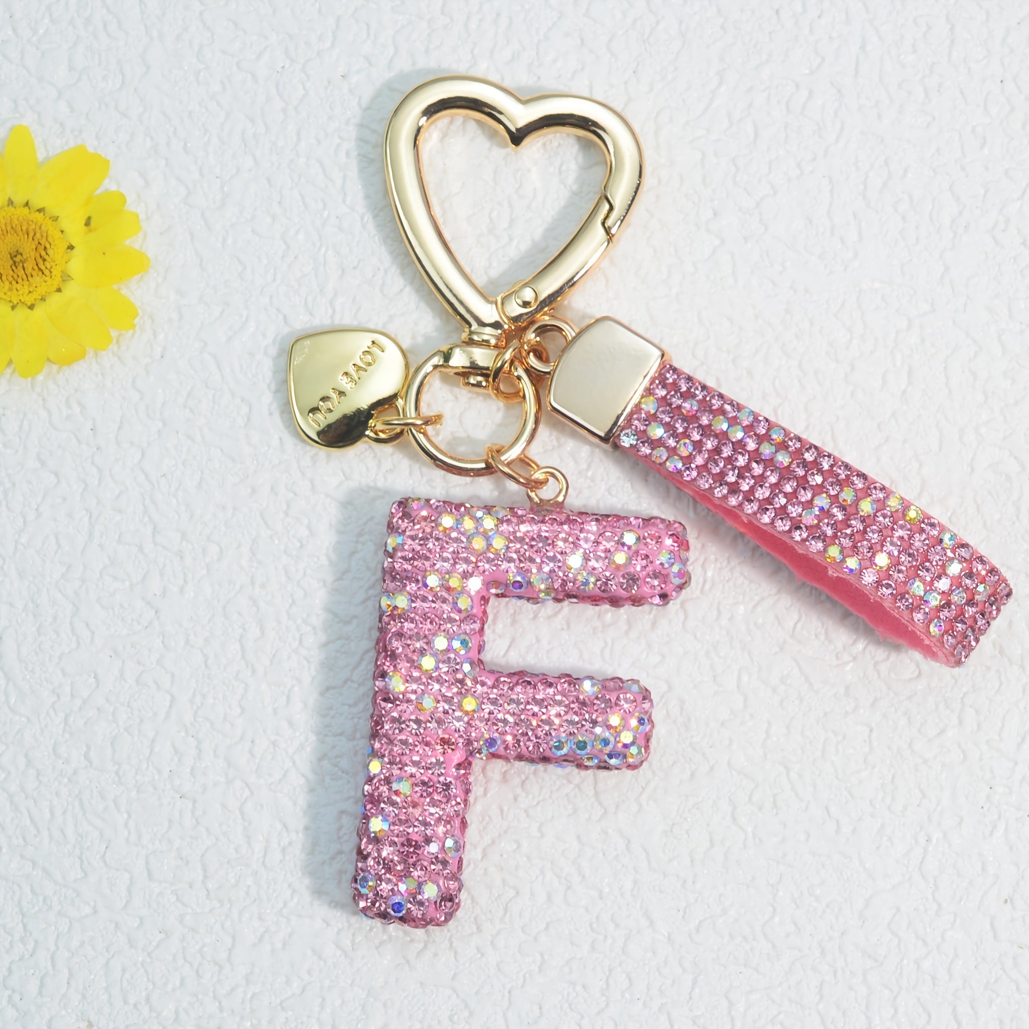 Llavero de PVC con iniciales de pedrería rosa y blanca con cierre de puño para mujeres