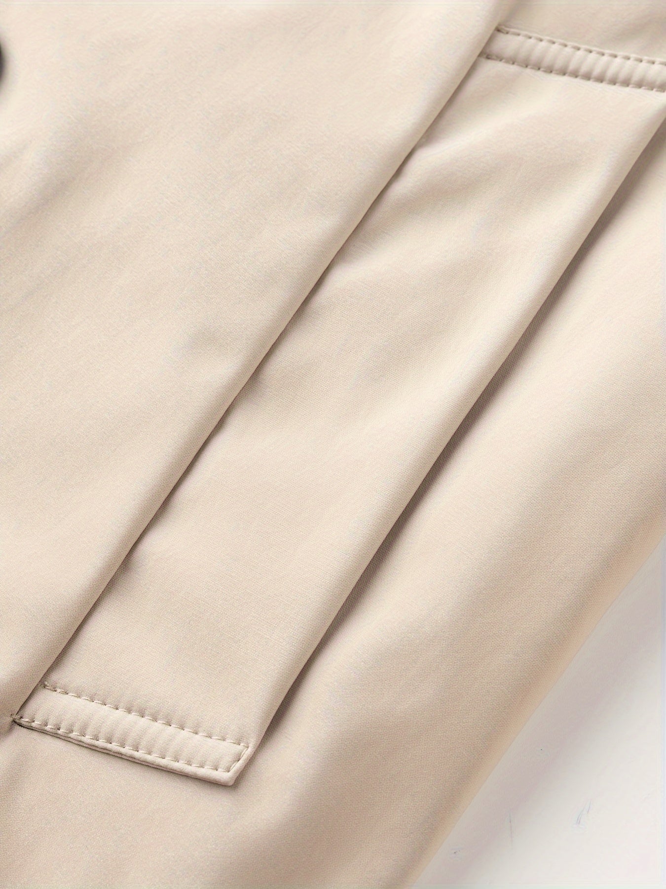 Erkaklar uchun o'rtacha uzunlikdagi ikki qatorli dizayndagi trench palto, mustahkam rangda, biznes va norasmiy kiyimlar uchun ideal.