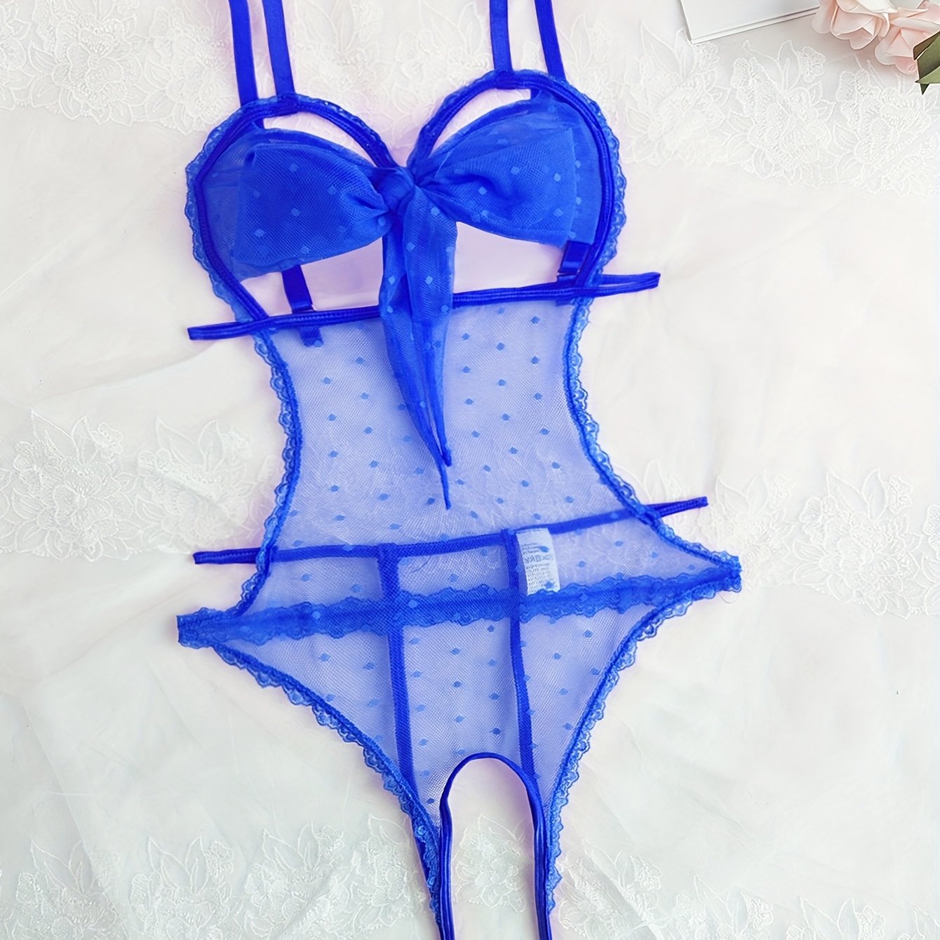 Teshikli, shaffof, old qismida tasma va bog'ich detali bo'lgan dantel patchwork bodysuit.