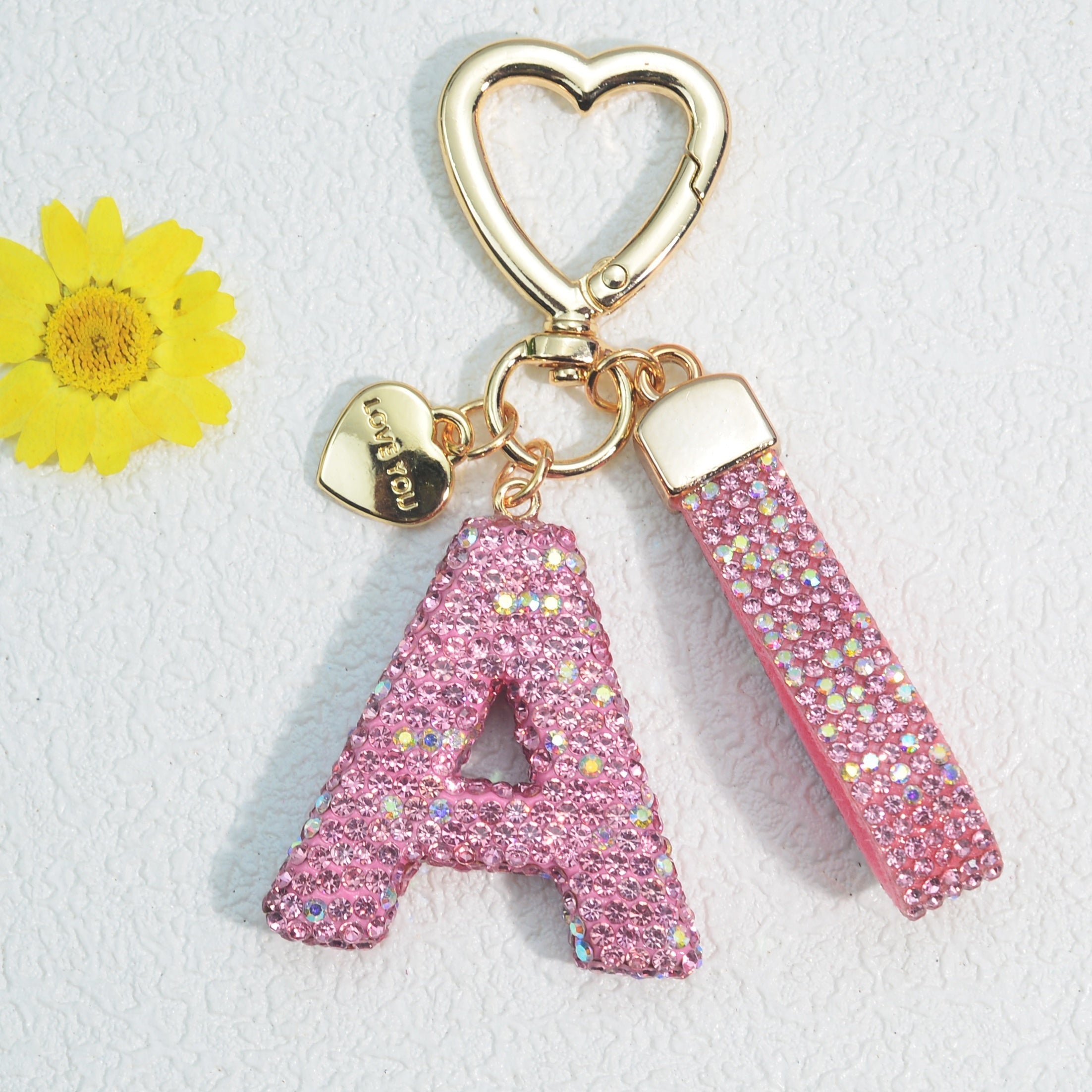 Llavero de PVC con iniciales de pedrería rosa y blanca con cierre de puño para mujeres