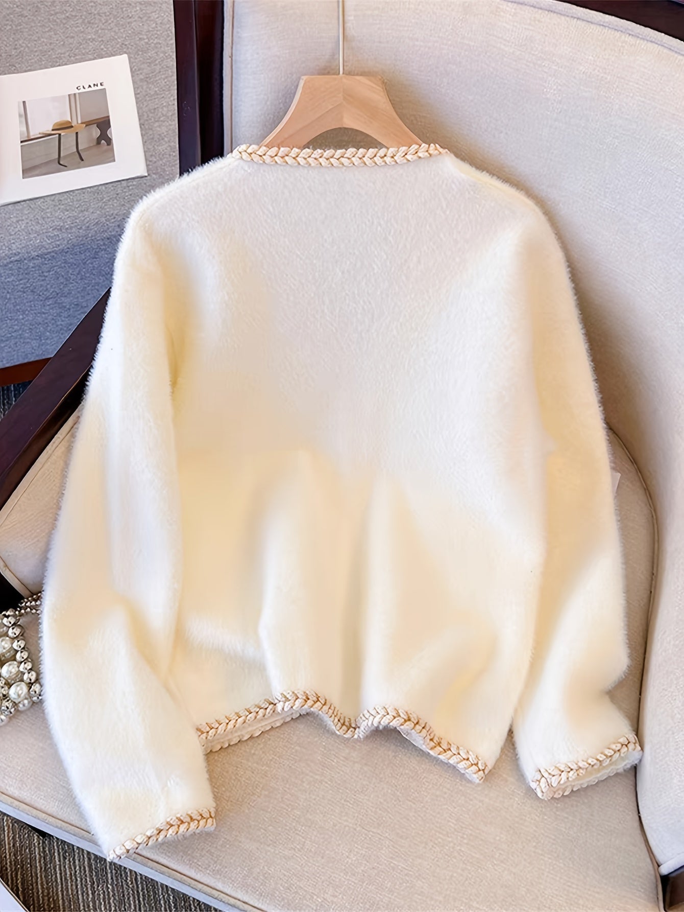 Zarif V-shaklidagi kardigan, soxta marvarid tugmalari bilan, akril va polyester aralashmasidan tayyorlangan, barcha fasllar uchun ideal.