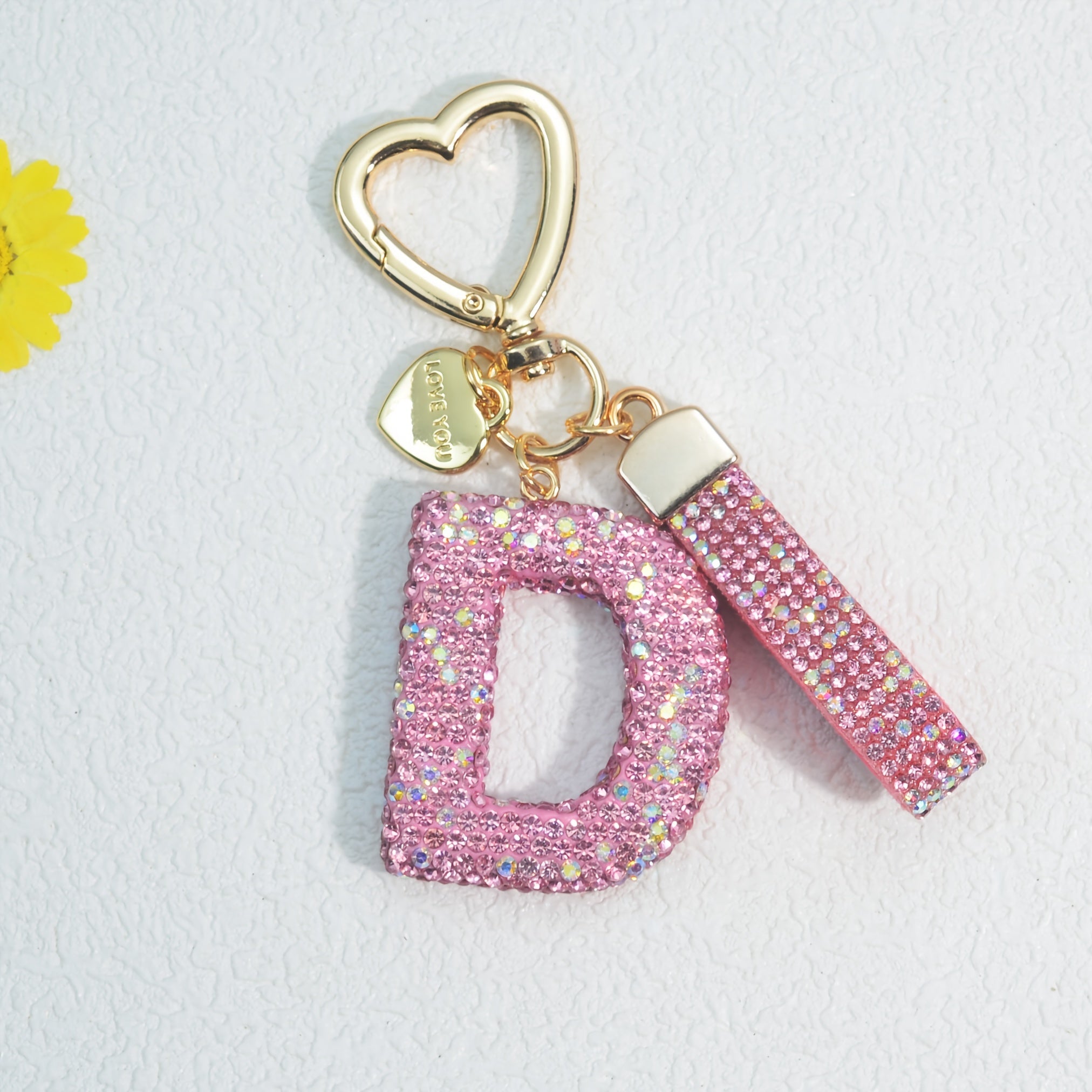 Llavero de PVC con iniciales de pedrería rosa y blanca con cierre de puño para mujeres