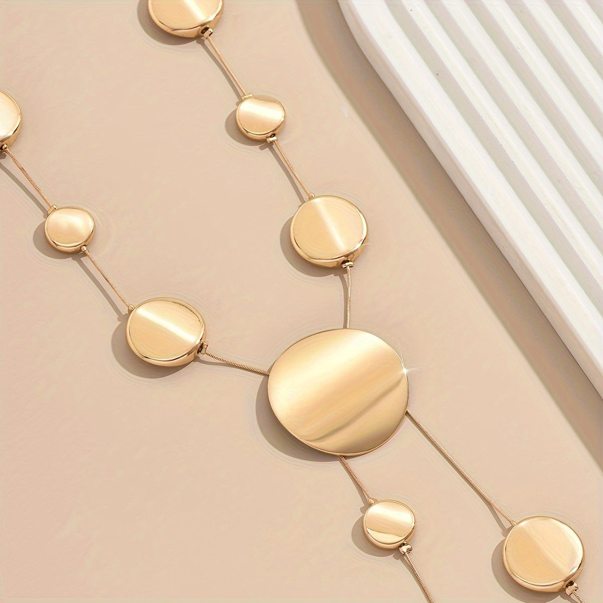 Zarif oltin ranglarida uslubiy uzun Y-shaklidagi marjon, geometrik dumaloq toshlar bilan - osonlik bilan zamonaviy va modali, har kuni kiyish uchun ideal.