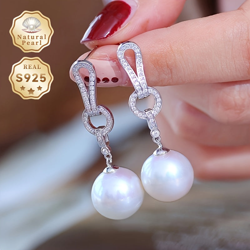 Kolleksiyangizga ushbu zarur Pearl Dangling Earrings bilan nafislik qo'shing. 13-14mm dumaloq tabiiy shirin suv marvaridlari bilan tayyorlangan, ushbu zamonaviy uzun sirg'alar S925 kumushdan yasalgan. Har bir juftlik noyob bo'lib, turli shakl va ...