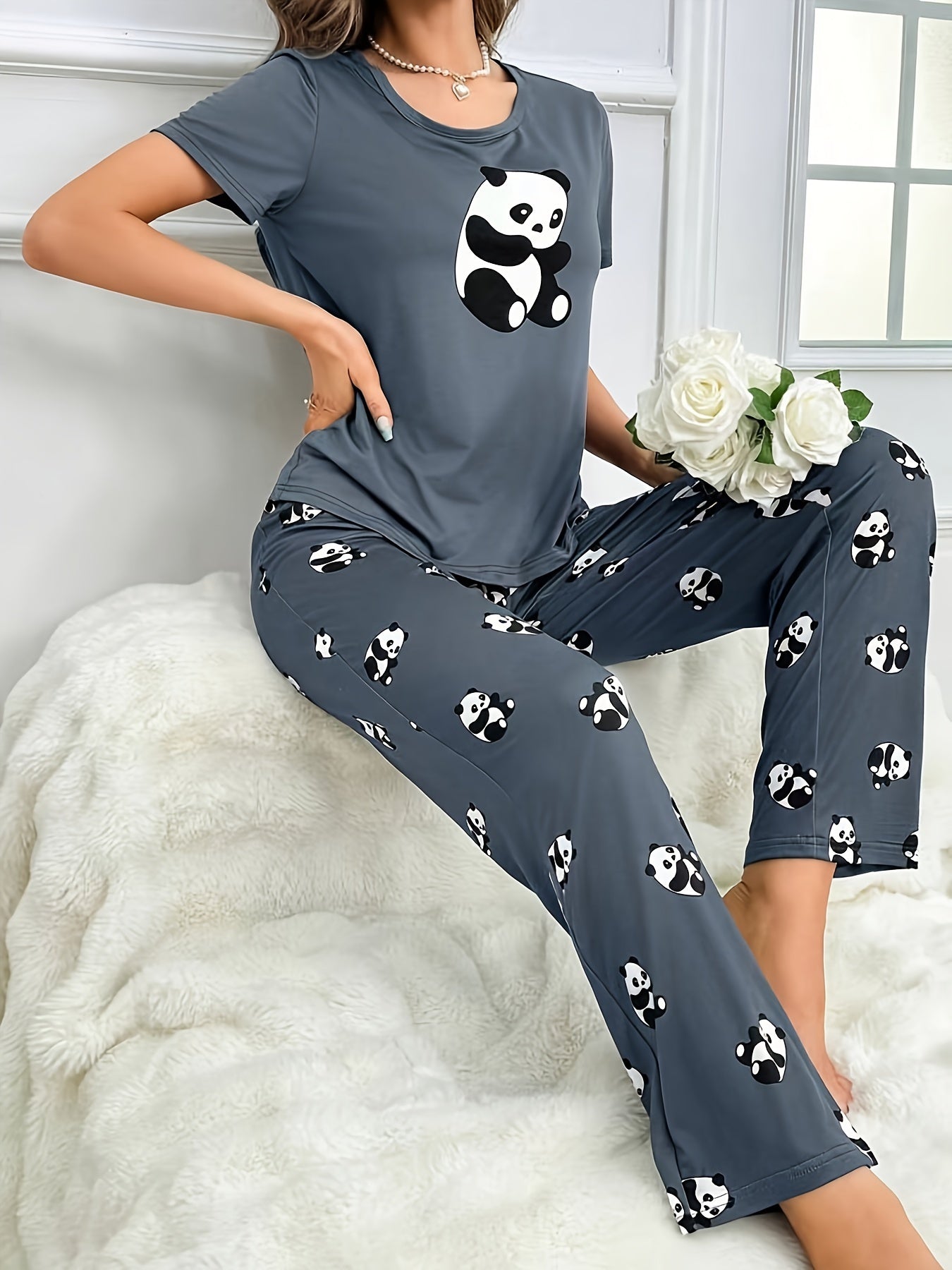 Ayollar uchun qora kulrangda sevimli panda naqshli pijama to'plami, yumshoq polyester va elastan aralashmasidan tayyorlangan. Qisqa yengli, yumshoq bo'yinli yuqori va uzun shimlar mavjud. Mashinada yuvish mumkin.