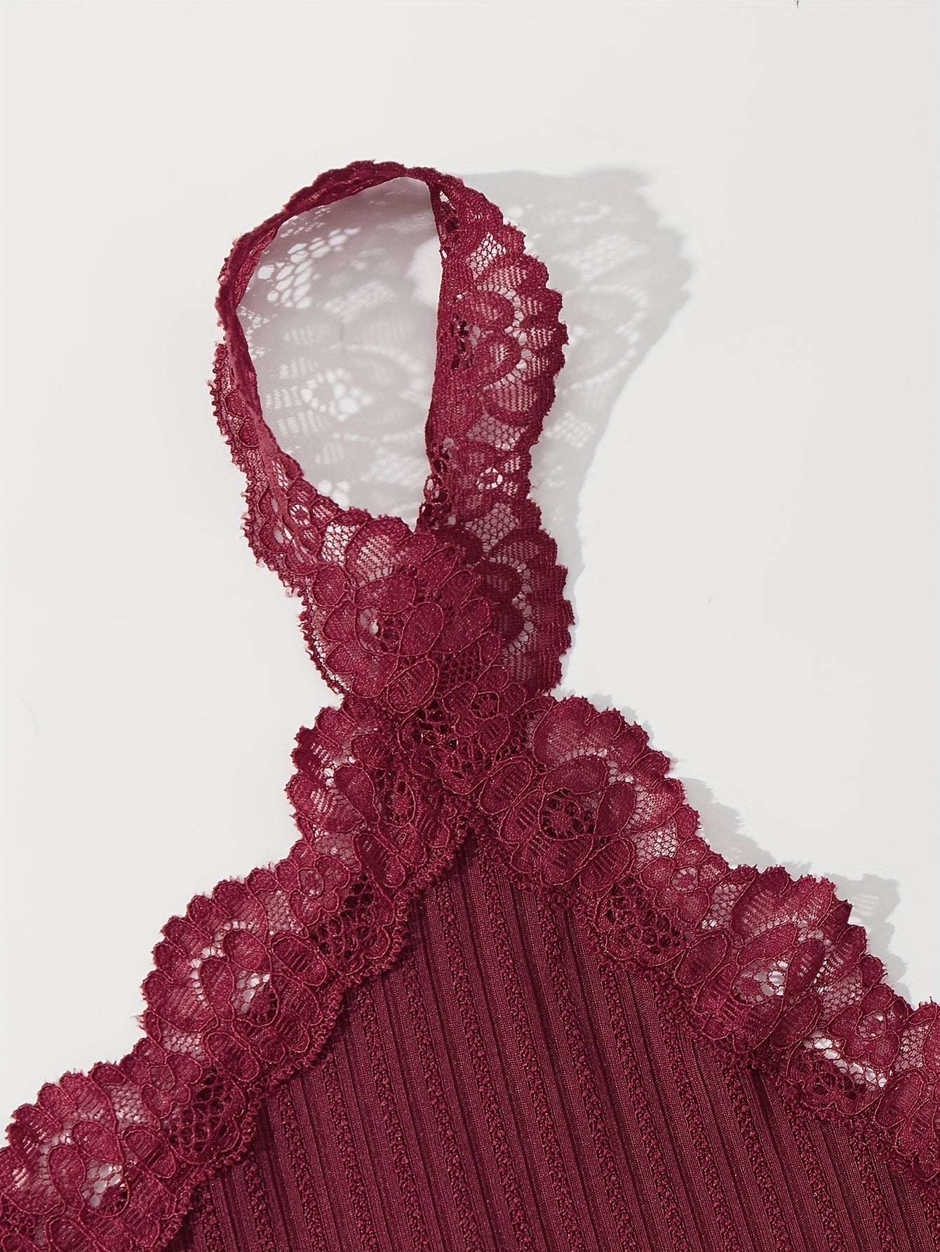 3-qismli dantel tikuvli lounge to'plami V-shaklidagi kamzuli bluzka va elastik belli shortlardan iborat bo'lib, ayollarning uyda kiyish va uxlash kiyimlari uchun mo'ljallangan.