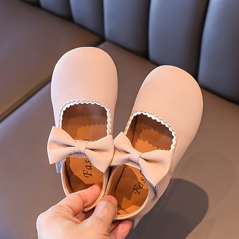 Qizlar uchun chiroyli bog'ich detali, yumshoq taglik, qora, jigarrang va bej rangda yopishqoq tasma bilan yopiladigan tekis poyabzal, qulay yurish uchun mustahkam PU material.