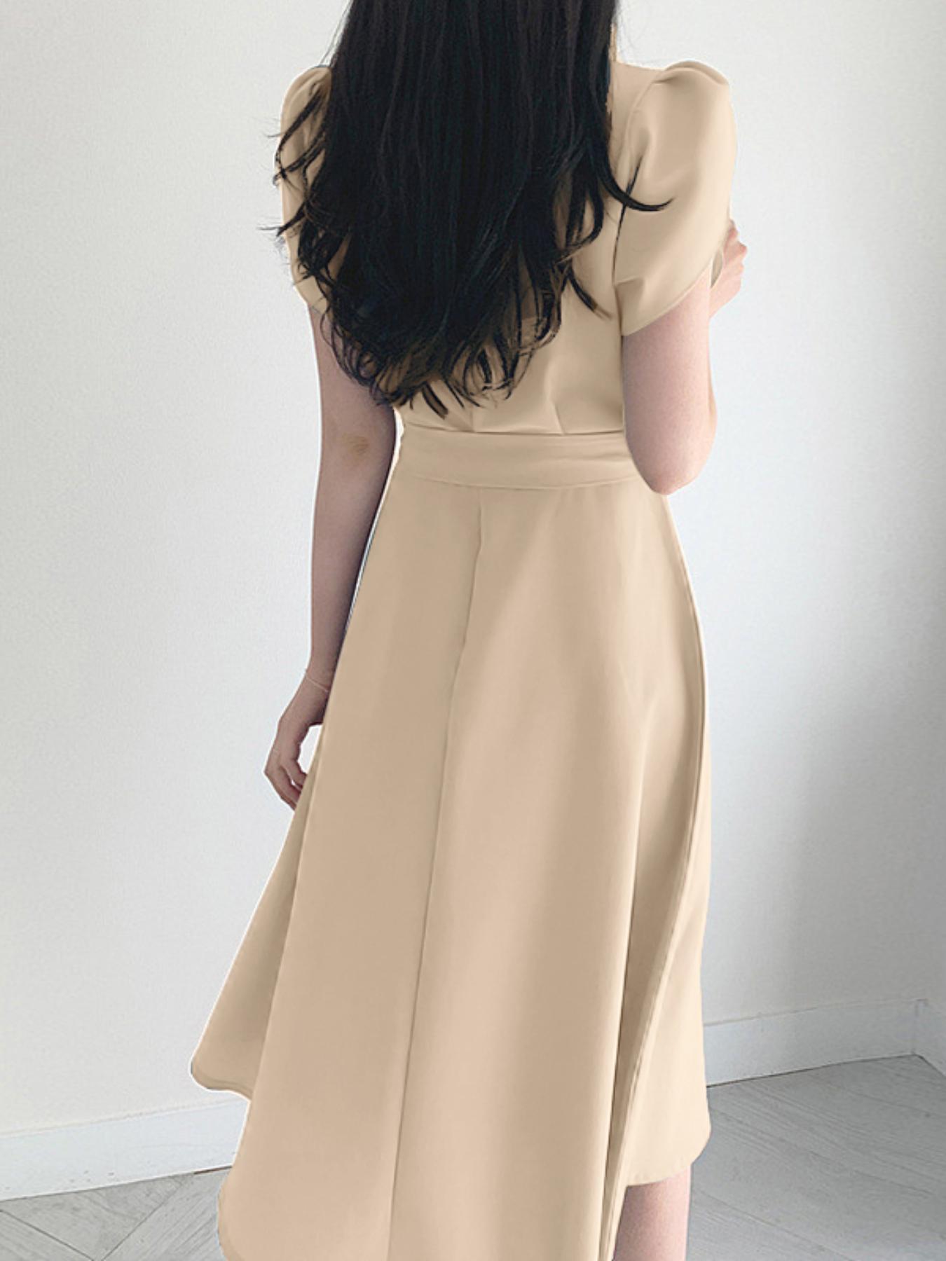 Zamonaviy V-shaklidagi A-siluetli ko'ylak, old tomonda o'ralgan, yengsiz va beli bezakli, kundalik yoki uchrashuvlar uchun. Yoz uchun engil polyesterdan tayyorlangan.