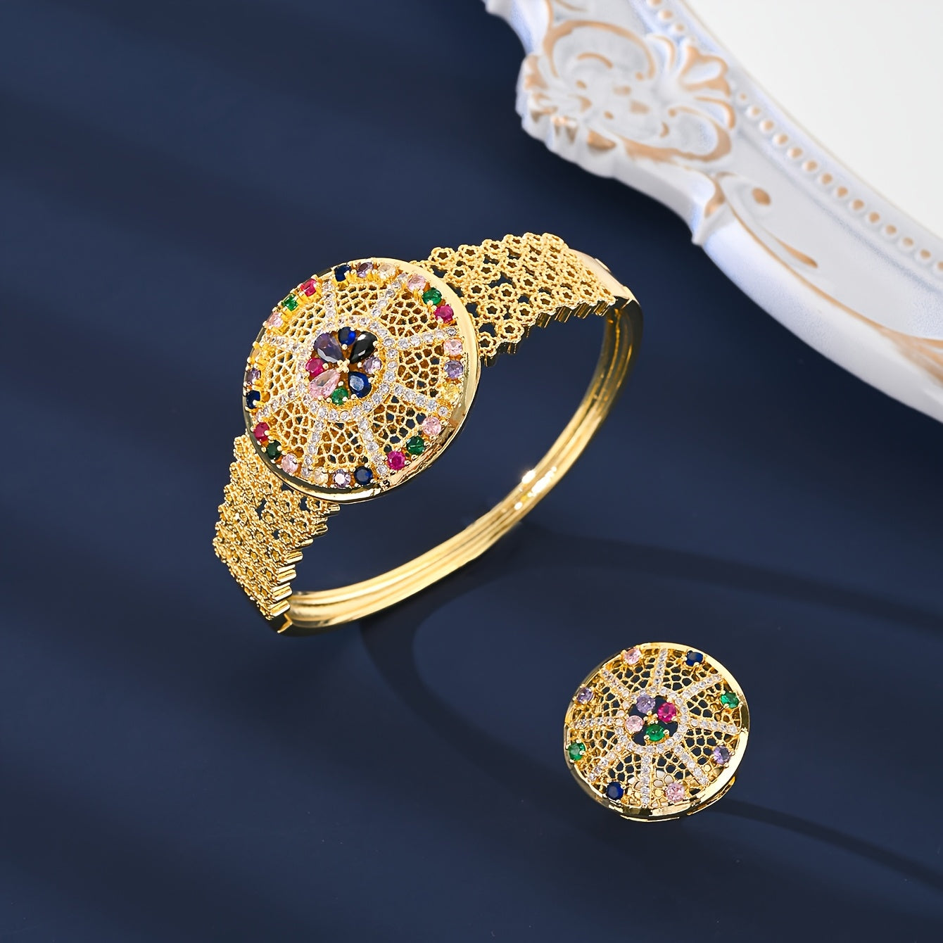 Nafis 4-qismli zargarlik to'plami - 18K oltin qoplamali misdan tayyorlangan va rang-barang zirkoniya toshlari bilan bezatilgan Arab vintage uslubida. To'plamga uzuk, taqinchoq, marjon va bilaguzuk kiradi - to'y va bayram tadbirlari uchun ideal.