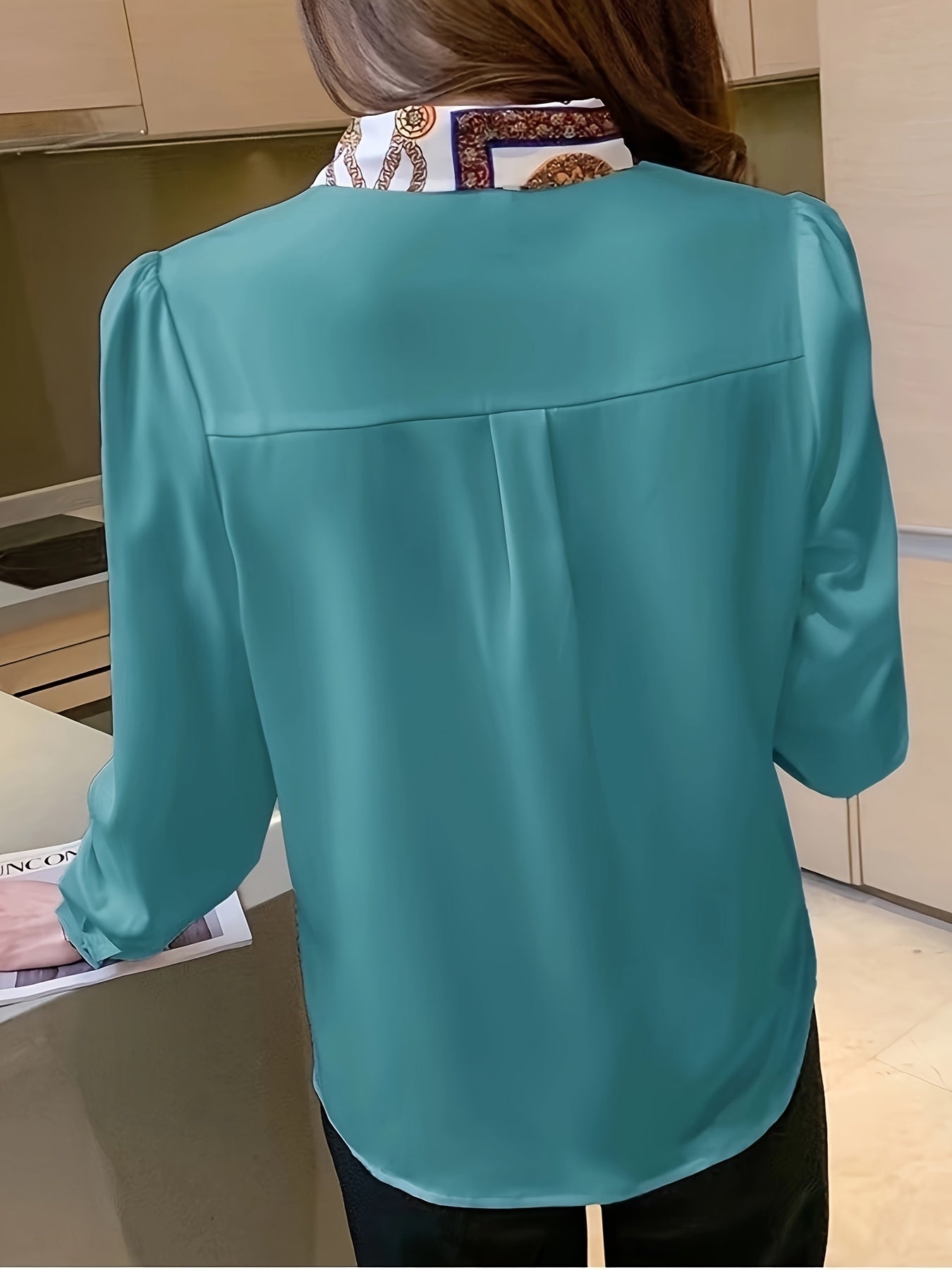 Blusa de mujer de poliéster con lazo en el cuello, manga larga, con botones y estampado en tejido.