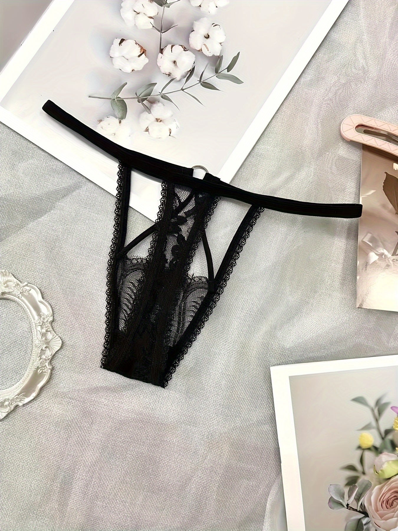 Ayollar uchun jozibali ichki kiyimlar to'rli, kesilgan past bel dizayni bilan thongni o'z ichiga oladi.