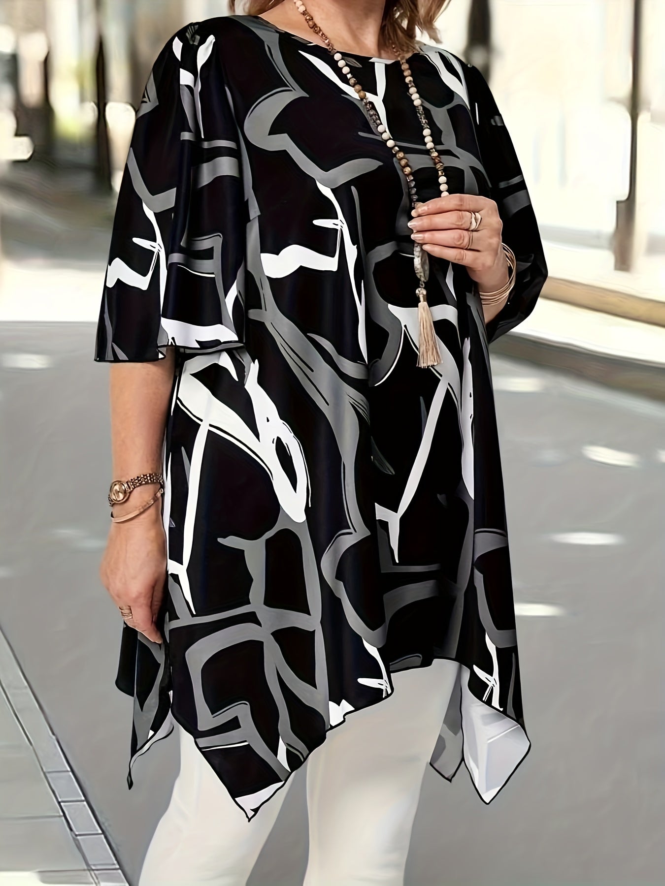 Top de mujer talla grande asimétrico negro y blanco con diseño geométrico de manga larga