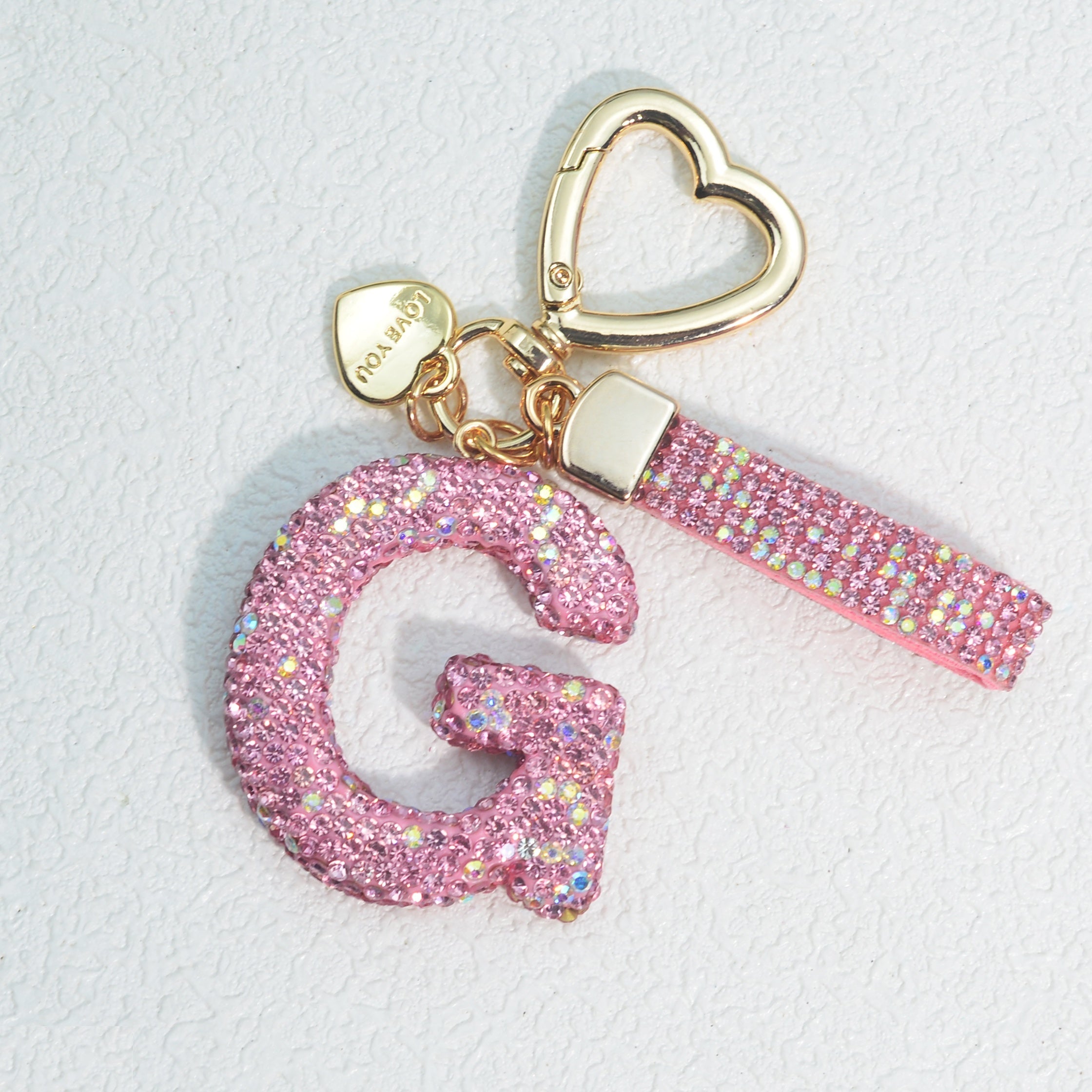 Llavero de PVC con iniciales de pedrería rosa y blanca con cierre de puño para mujeres