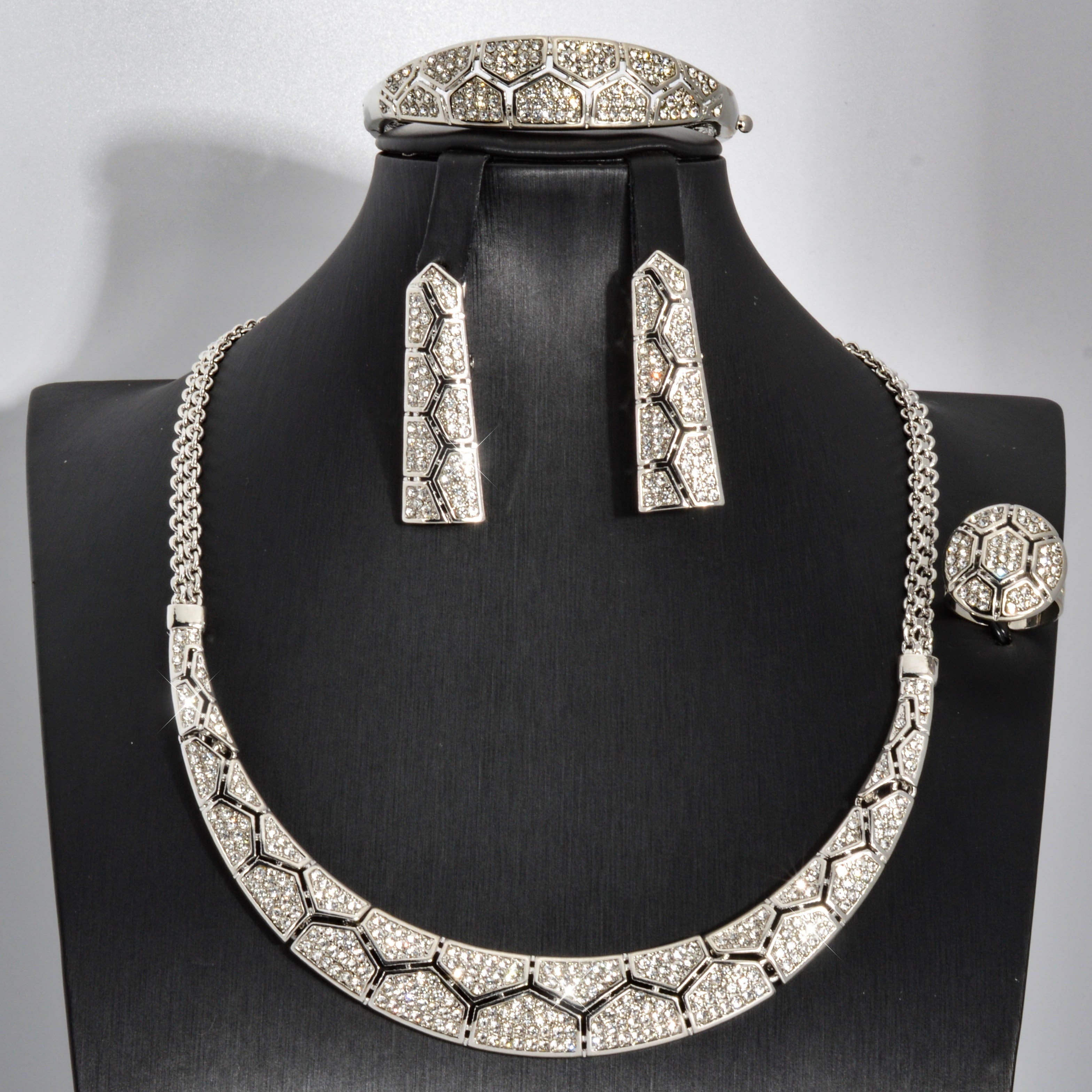 ZEADEAR mis zargarlik to'plami hashamatli va nafis bo'lib, go'zal mozaika naqshida porlaydigan Zirconia bilan bezatilgan. Ushbu to'plam ajoyib Geometrik Pentagon marjon, bilaguzuk, sirg'a va uzukni o'z ichiga oladi, to'ylar va banketlar uchun mukammal.