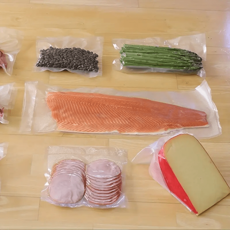 PE+PA materialidan tayyorlangan 1500cm (590.55in) qo'shimcha uzunlikdagi oziq-ovqat paketlash sumkasi ruloni. Baliq, losos, go'sht, meva va sabzavotni vakuumli yopishtirish uchun ideal, oshxona saqlash va yangi holatini saqlash uchun optimal.