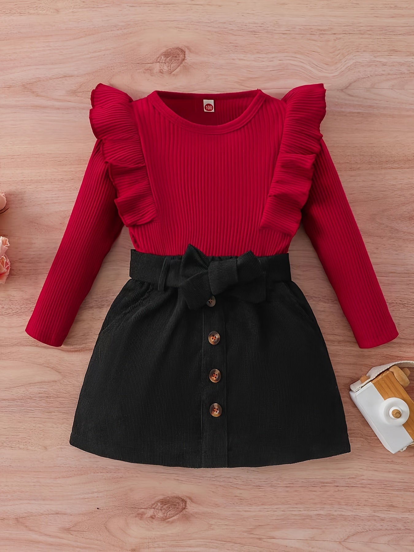 Yevropa va Amerika uslubidagi qizlar uchun kuz va qish kiyimi, ikki qismli to'plamda uchuvchi yengli bolalar bluzkasi va zamonaviy korduroy yubkasi mavjud.