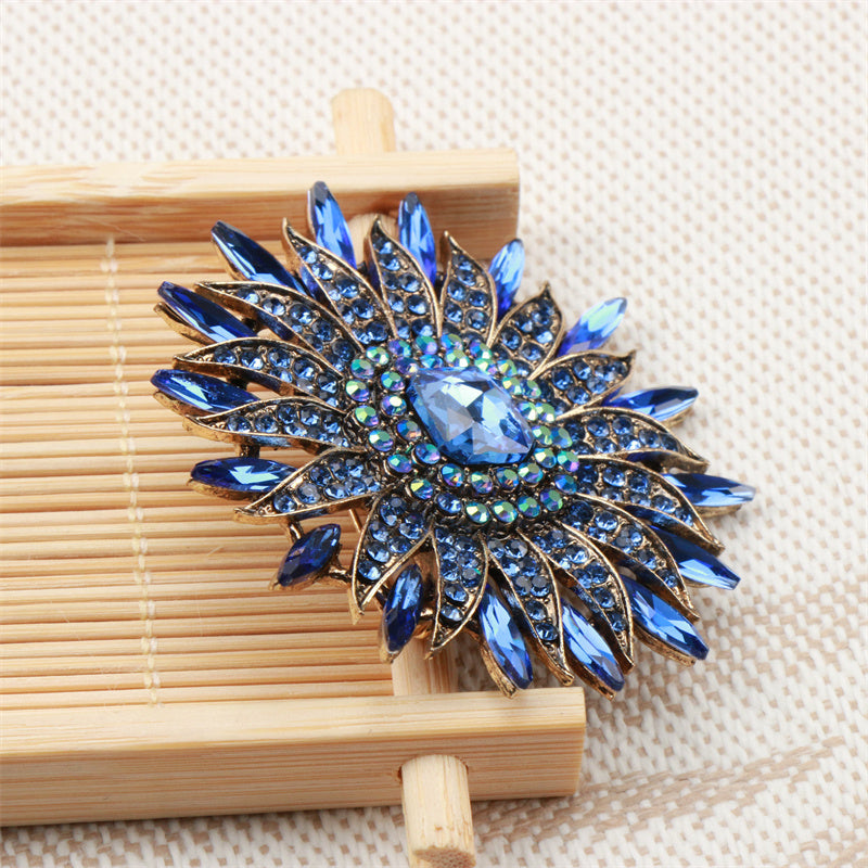 Bir nafis quyoshguli brosh, hashamatli kristal gullar bilan bezatilgan, o'ziga xos nishon, joziba va nafislikni tarqatadi. Do'stlar uchun mukammal aksessuar sovg'asi.