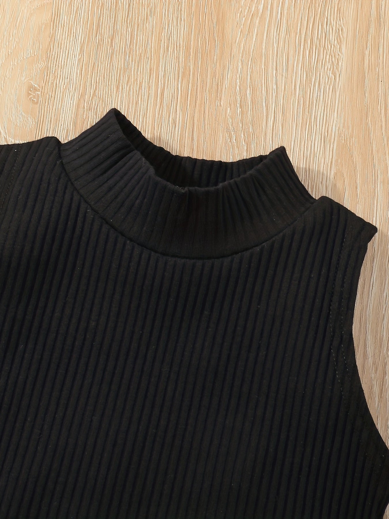 Yuqori yengsiz ko'ylak, pliseli yubka va kamar bilan.