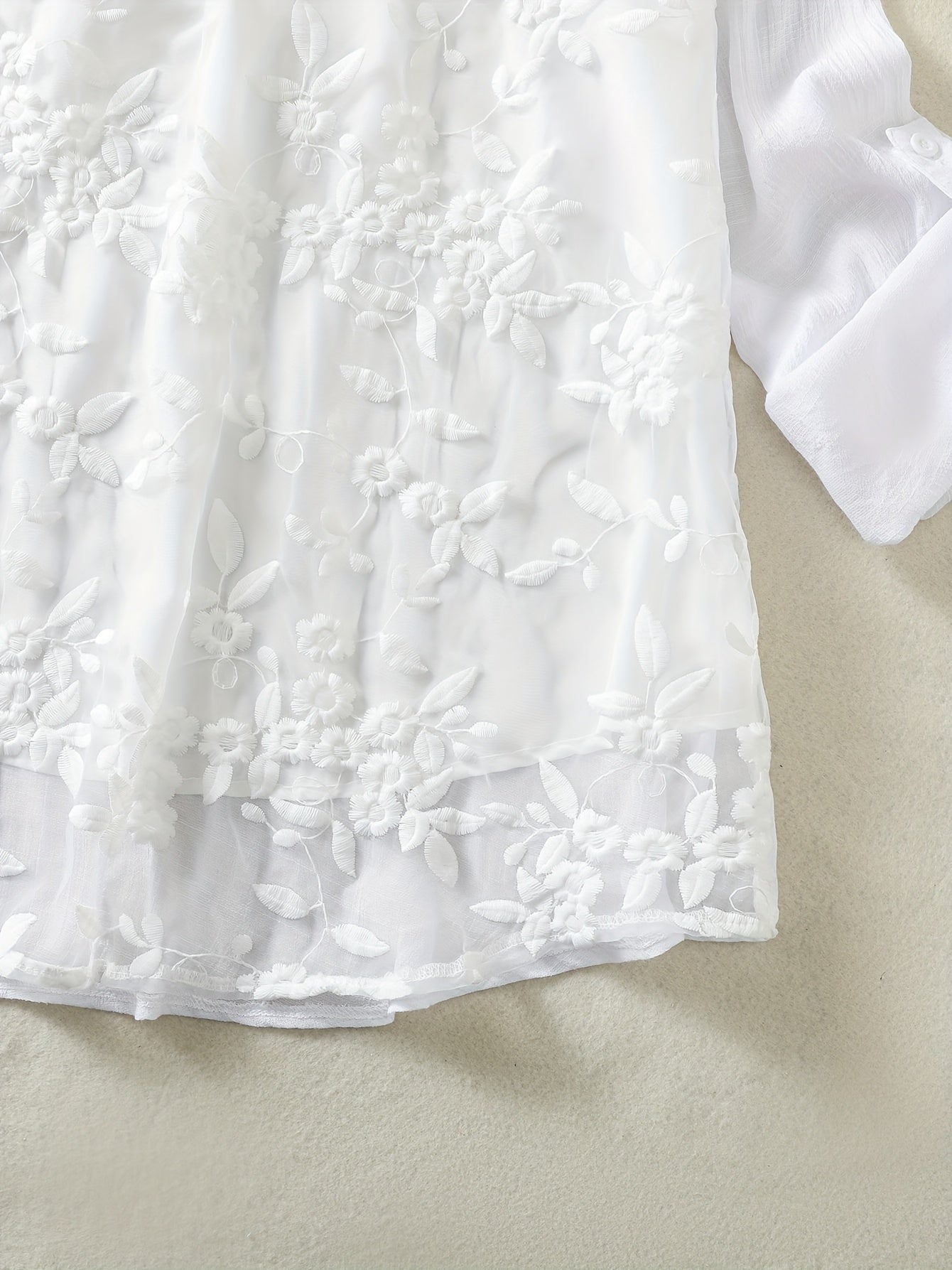 V-yuqori plus o'lchamdagi bluzka, kengaytirilgan pastki qismi va tugma tafsiloti bilan, barcha mavsumlar uchun mos keladigan, cho'zilmaydigan polyester matodan tayyorlangan, bir rangda.