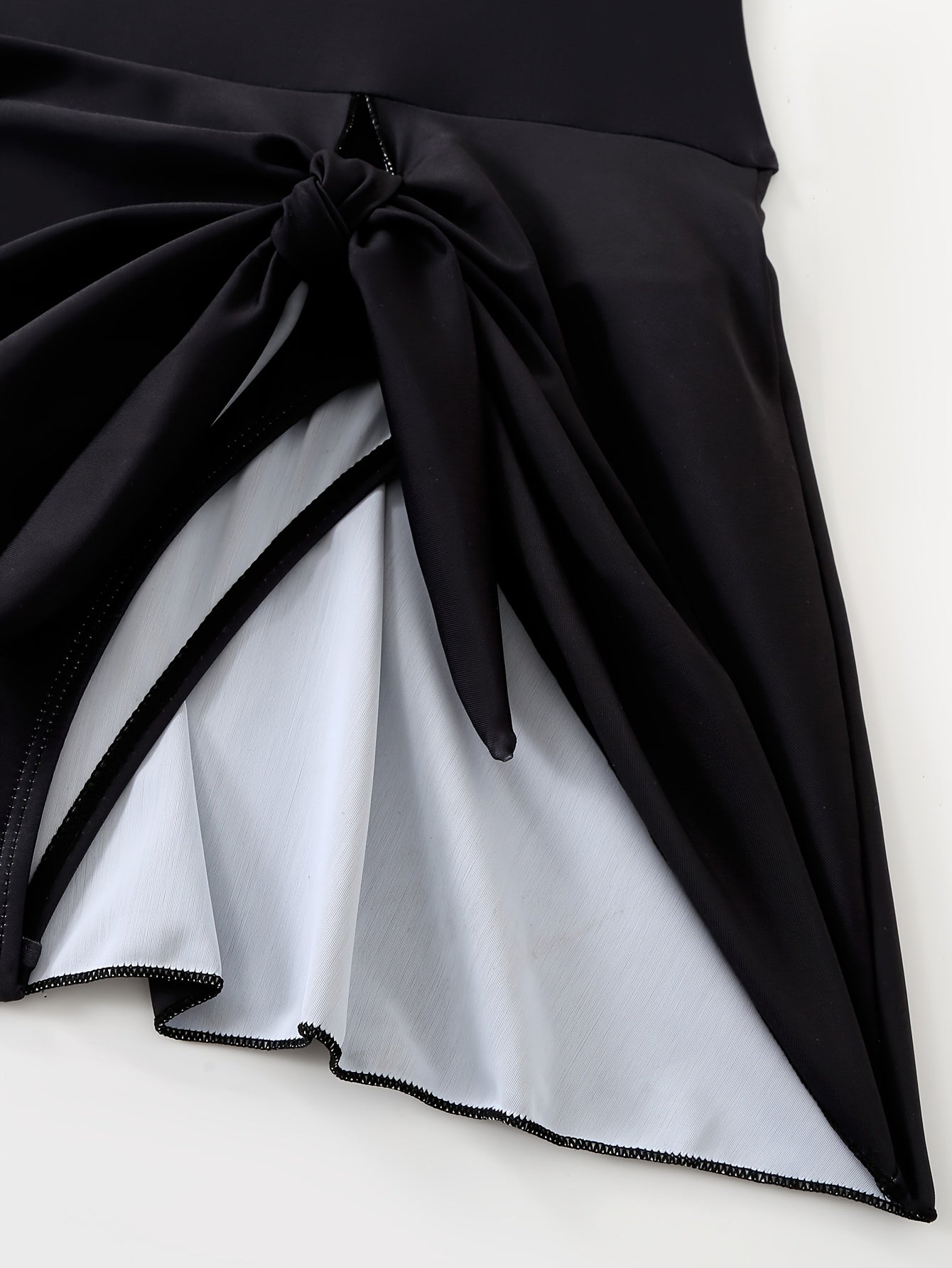 Gul naqshli suzish kiyimi, yubka shaklidagi pastki qismi, qora va oq rangda ingichka yuqori bel dizayni, cho'ziluvchan polyester/elastan aralashmasi, olib tashlanadigan yostiqlar, plyaj va basseyn uchun mukammal.