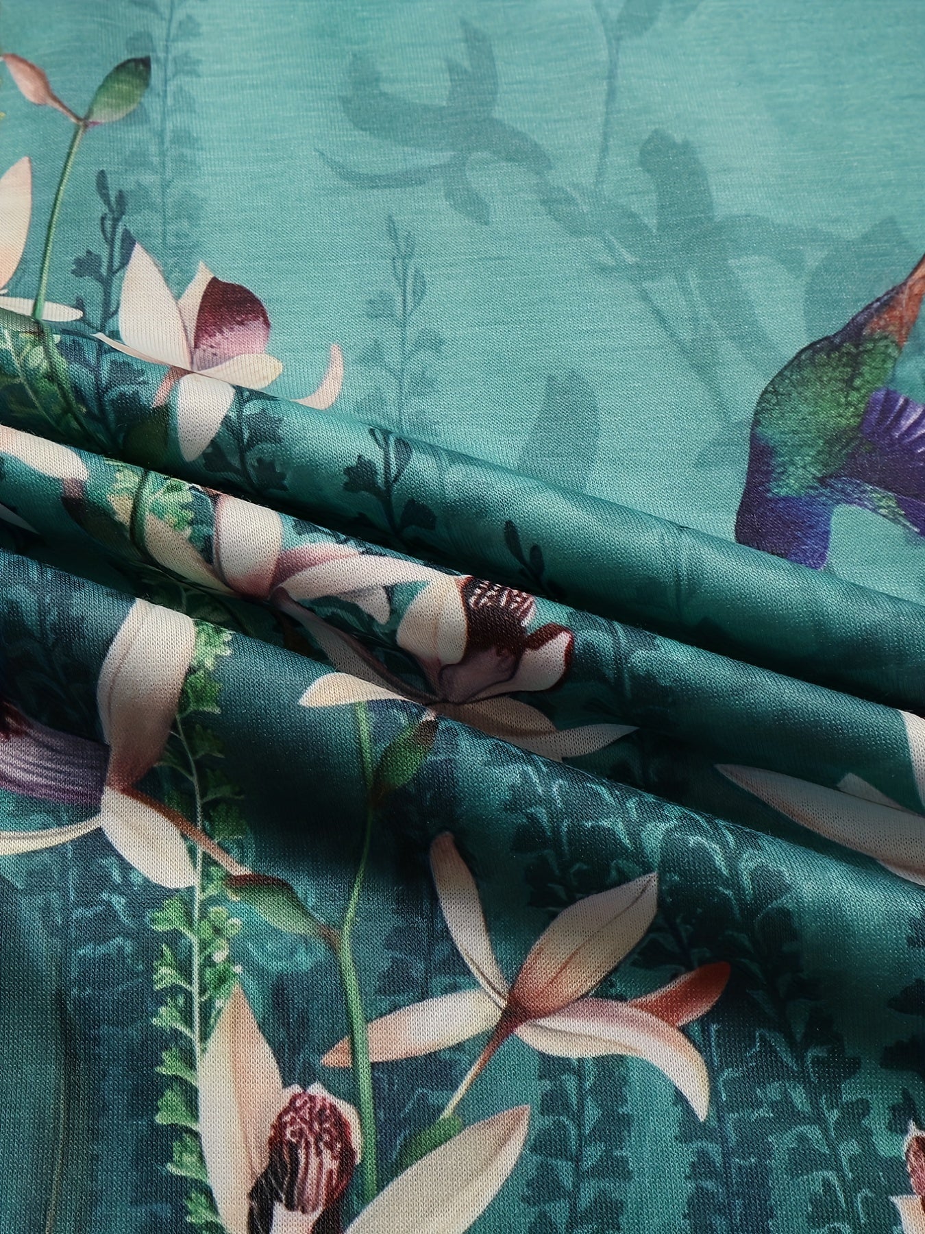 Ayollar uchun kattaroq o'lchamdagi gullar bilan bosilgan qisqa ko'ylakli, dumaloq bo'yinli, qisqa qo'lqopli T-shirt