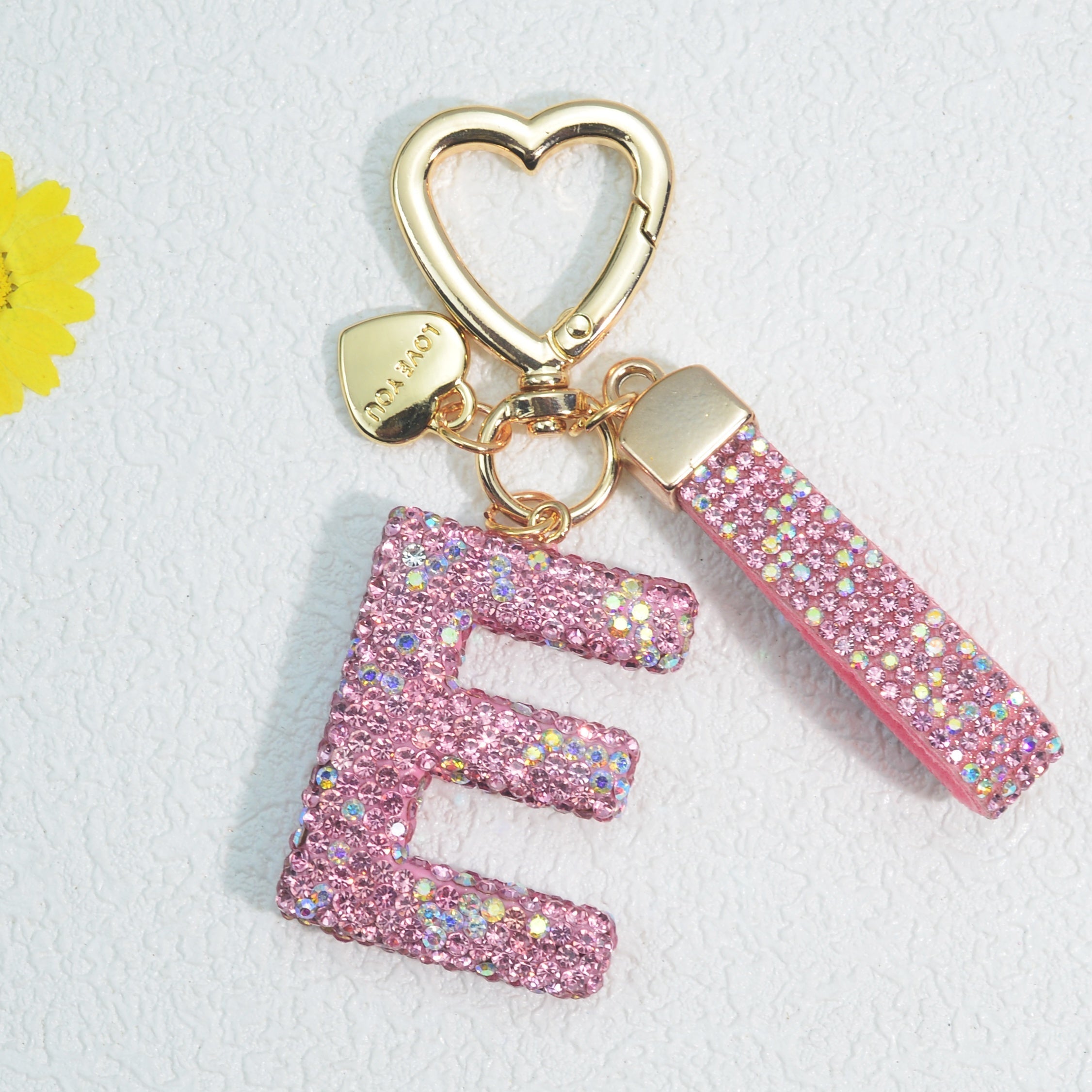 Llavero de PVC con iniciales de pedrería rosa y blanca con cierre de puño para mujeres