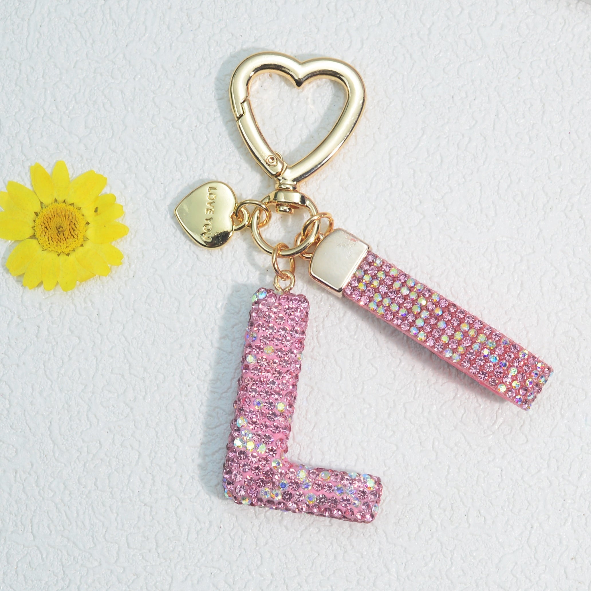 Llavero de PVC con iniciales de pedrería rosa y blanca con cierre de puño para mujeres