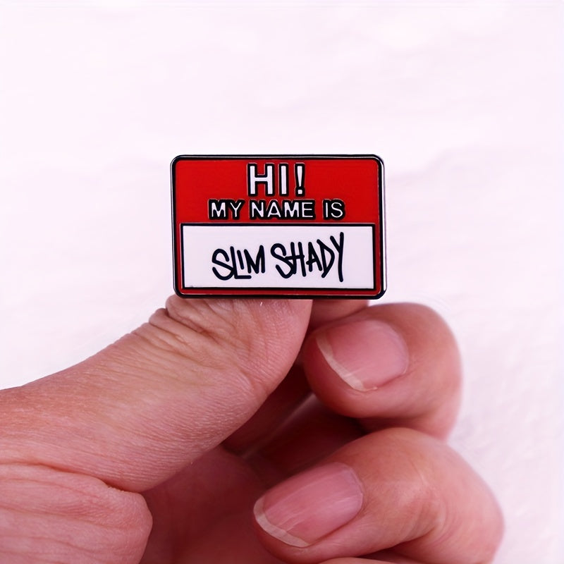 Mening sirli va qiziqarli ismim bor. Men inglizcha yozuvli metall broshka yelkamda faxr bilan taqaman. Bu, musiqani, modani va uslubni ifodalovchi, reper Amu ning "Broshka" qo'shig'ida ko'rsatilgan broshka.