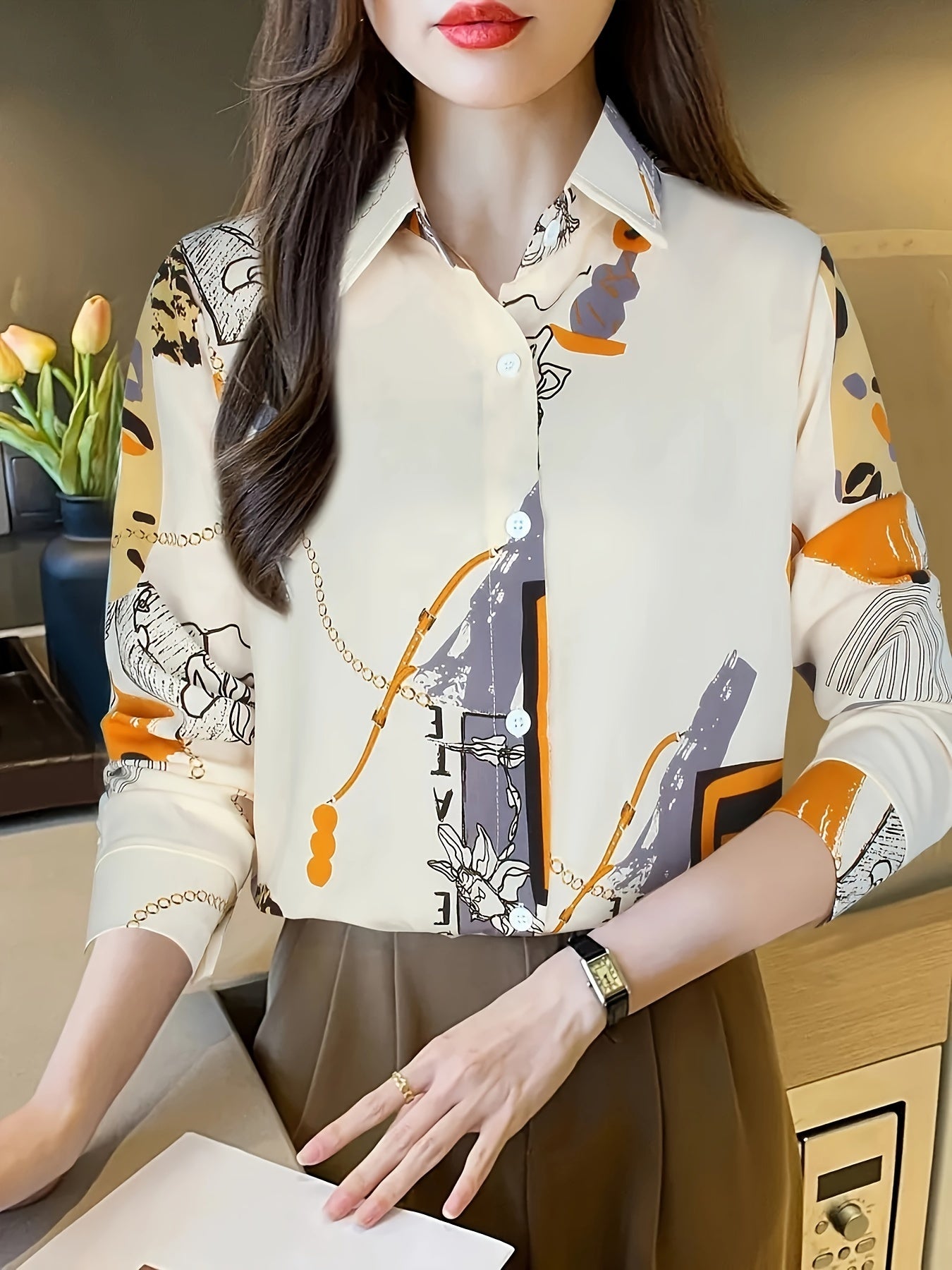 Vintage uslubidagi tugmachali bluzka, zanjir va gullar naqshli yaka bilan. 95% polyester va 5% spandeksdan tayyorlangan, geometrik naqshlar bilan. Uzoq yengli to'qilgan yuqori qism uchun mukammal.