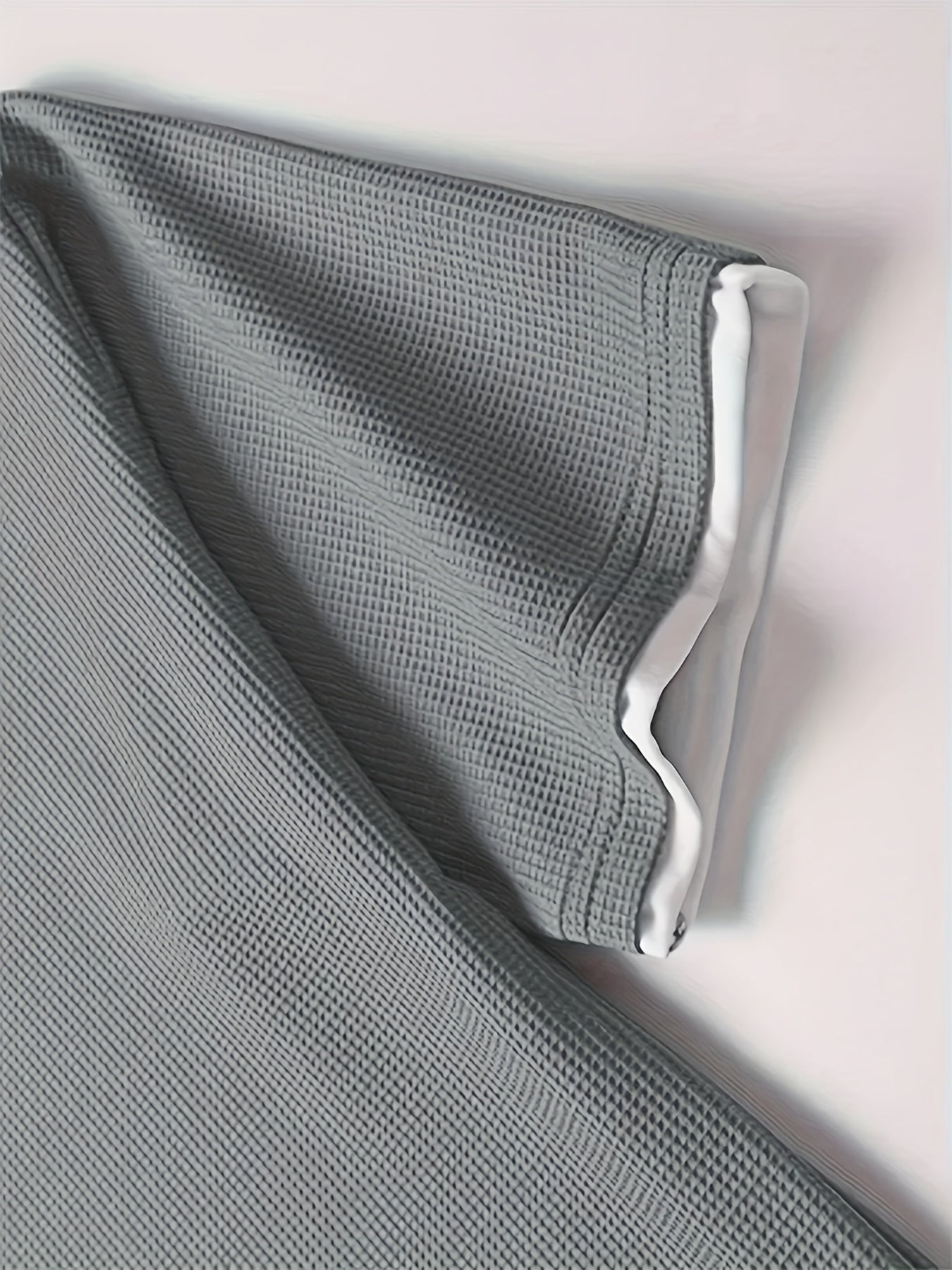 Erkaklar uchun tasodifiy vafli to'qilgan pijama to'plami, kulrang va qora rangda, qisqa yengli yuqori va elastik belga ega shortlar. Quyi qismida aplikatsiya bezaklari va qulaylik uchun yumshoq polyester mato mavjud.