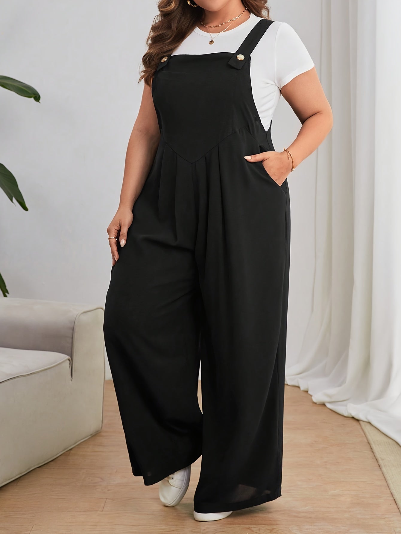 Keng oyoqli plussayz kombinezon, oddiy uslubda, bir rangli polyester matodan tayyorlangan. Yengsiz dizayn, cho'ntaklar bilan, barcha mavsumlar uchun mos.