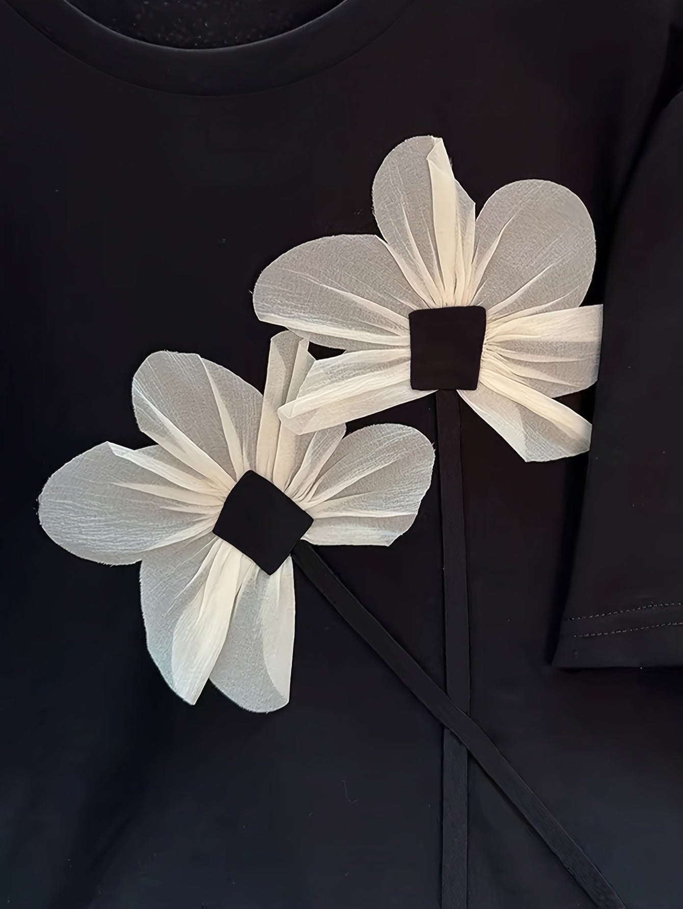 Ayollar uchun gullar bilan bezatilgan katta o'lchamdagi futbolka. Elastik polyester-spandeks aralashmasidan tayyorlangan. Dumaloq bo'yin, qisqa yeng, mashinada yuvish mumkin. Yozgi norasmiy yoki rasmiy kiyim uchun mos.