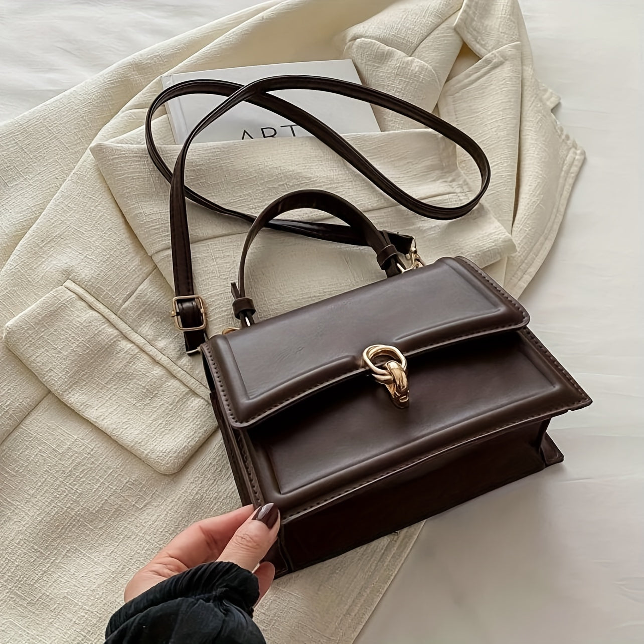 Элегантная черная синтетическая кожаная сумка для женщин с ретро-клапаном, верхней ручкой, замком с поворотом и золотистой фурнитурой. Имеет структурированную прямоугольную форму, регулируемый ремень.