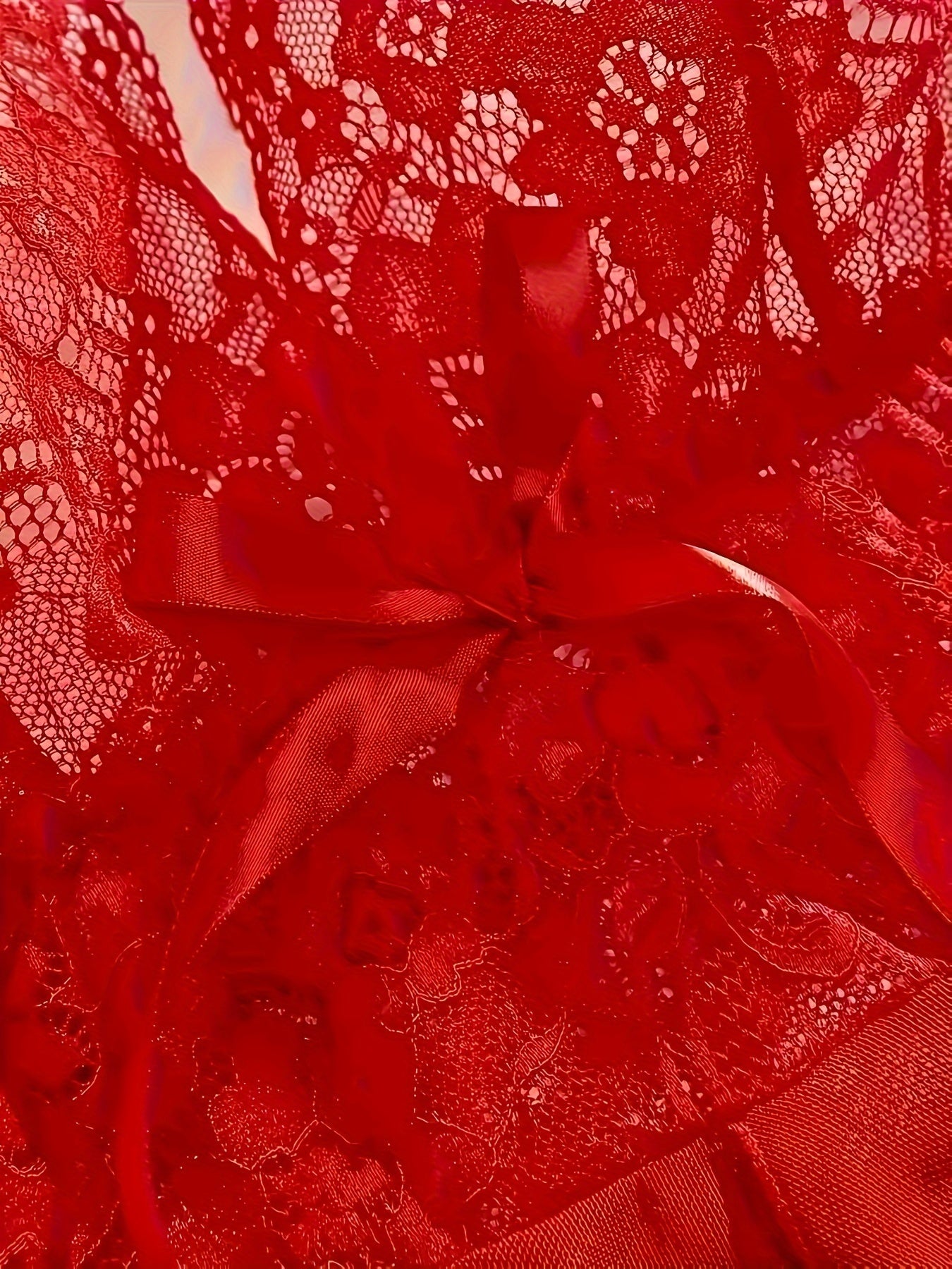 Jozibali ichki kiyim to'plami, dantel gullar naqshiga ega yarim shaffof chuqur V shaklidagi ko'ylak va thongni o'z ichiga oladi.