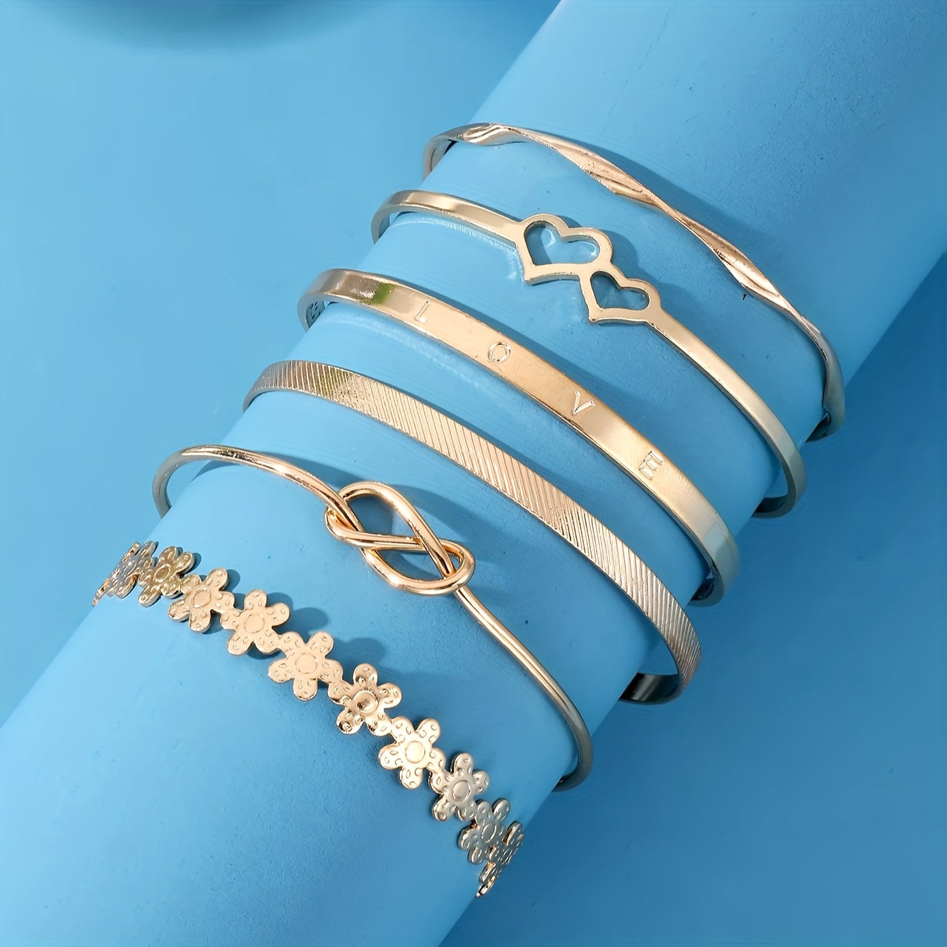 6 ta zamonaviy bilaguzuklar to'plami, gullar, tugunlar va yurak dizaynlariga ega. Ularni kundalik kiyimlaringiz yoki bayram kiyimlaringiz bilan birlashtiring. Ushbu sozlanadigan zargarlik buyumlari har qanday ko'rinishni bezatish uchun mukammaldir.