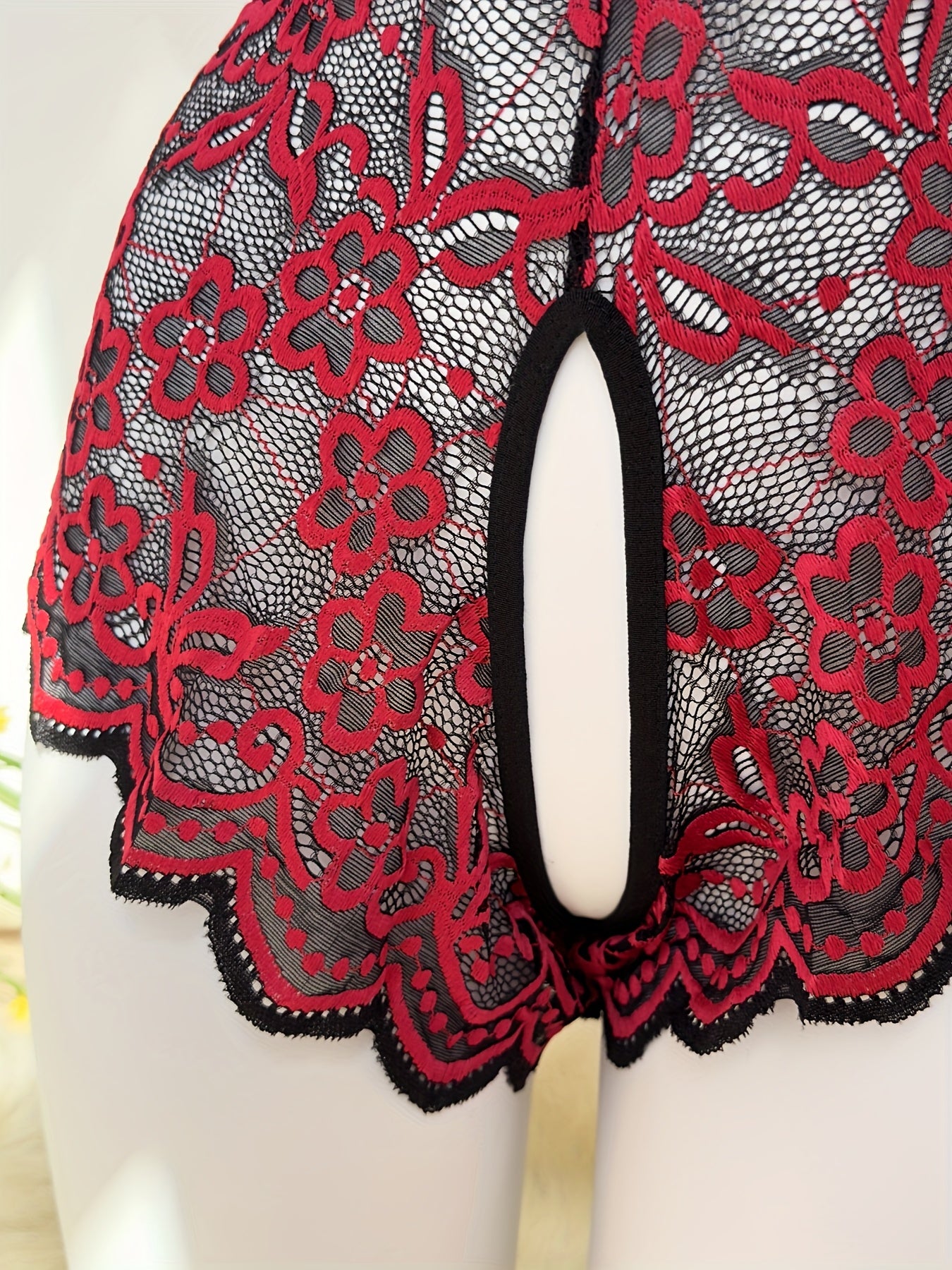 Jozibali dantel bodysuit, chuqur V-shakl, ochiq orqa va kesish tasma dizayni bilan.