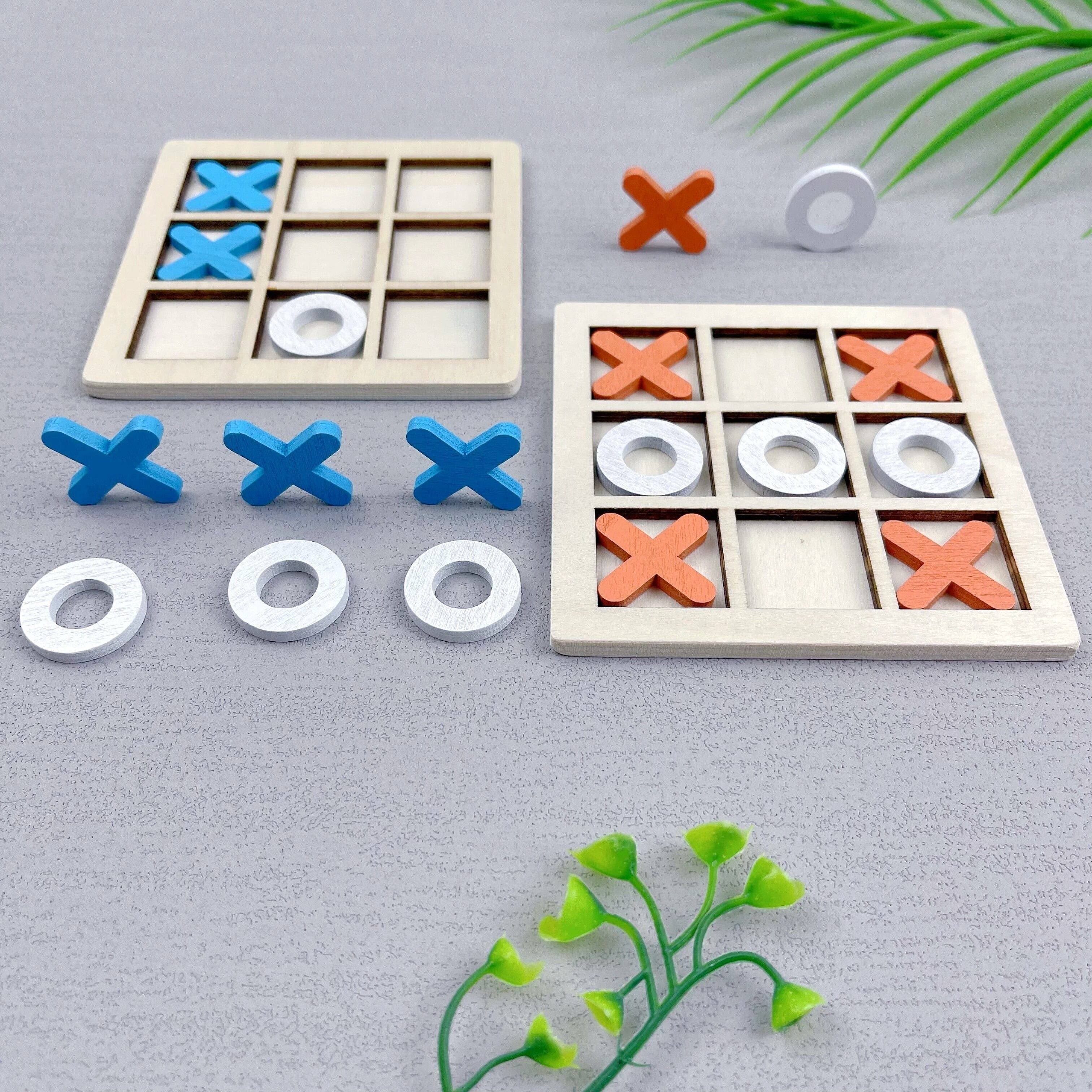 Ta'lim beruvchi, ikki o'yinchi uchun Tic Tac Toe o'yini, turli rangdagi yog'och XO qismlari bilan.