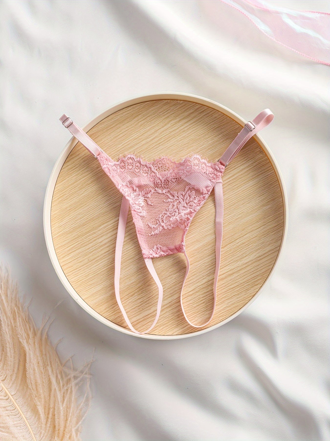 Gul dizayni, nozik kamarlar va orqa qismi ochiq kesimga ega bo'lgan ayollar uchun dantel ichki kiyim to'plami.