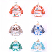 Babero impermeable para niños con bolsillos, diseño de dibujos animados, material suave, delantal de manga larga