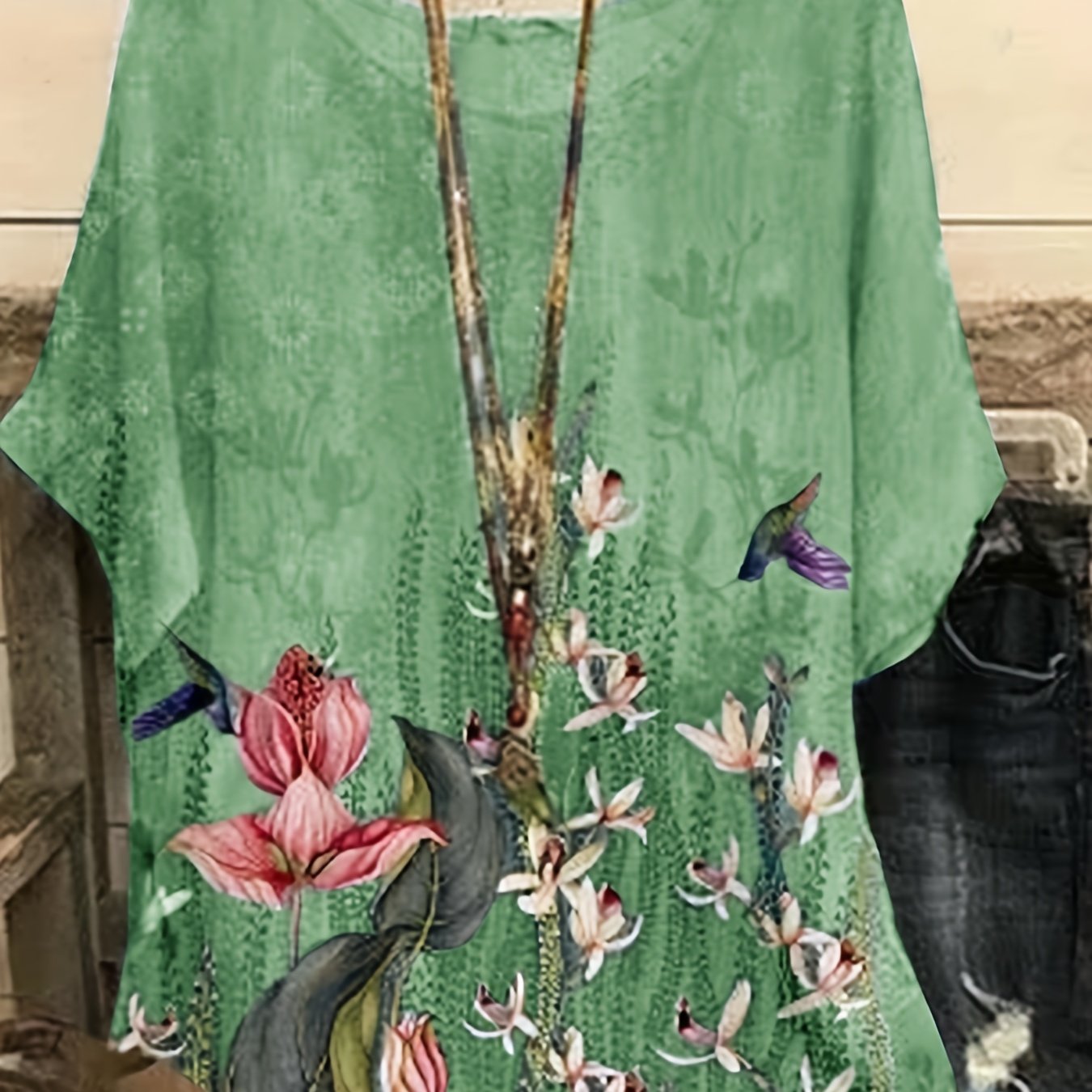 Ayollar uchun kattaroq o'lchamdagi gullar bilan bosilgan qisqa ko'ylakli, dumaloq bo'yinli, qisqa qo'lqopli T-shirt