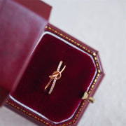 Ushbu ajoyib uzuk zamonaviy tugun dizayniga ega bo'lib, 925 sterling kumushdan tayyorlangan va porloq kubik zirkoniy aksentlari bilan bezatilgan. Bu sizning hayotingizdagi har qanday maxsus ayol uchun mukammal sovg'a.