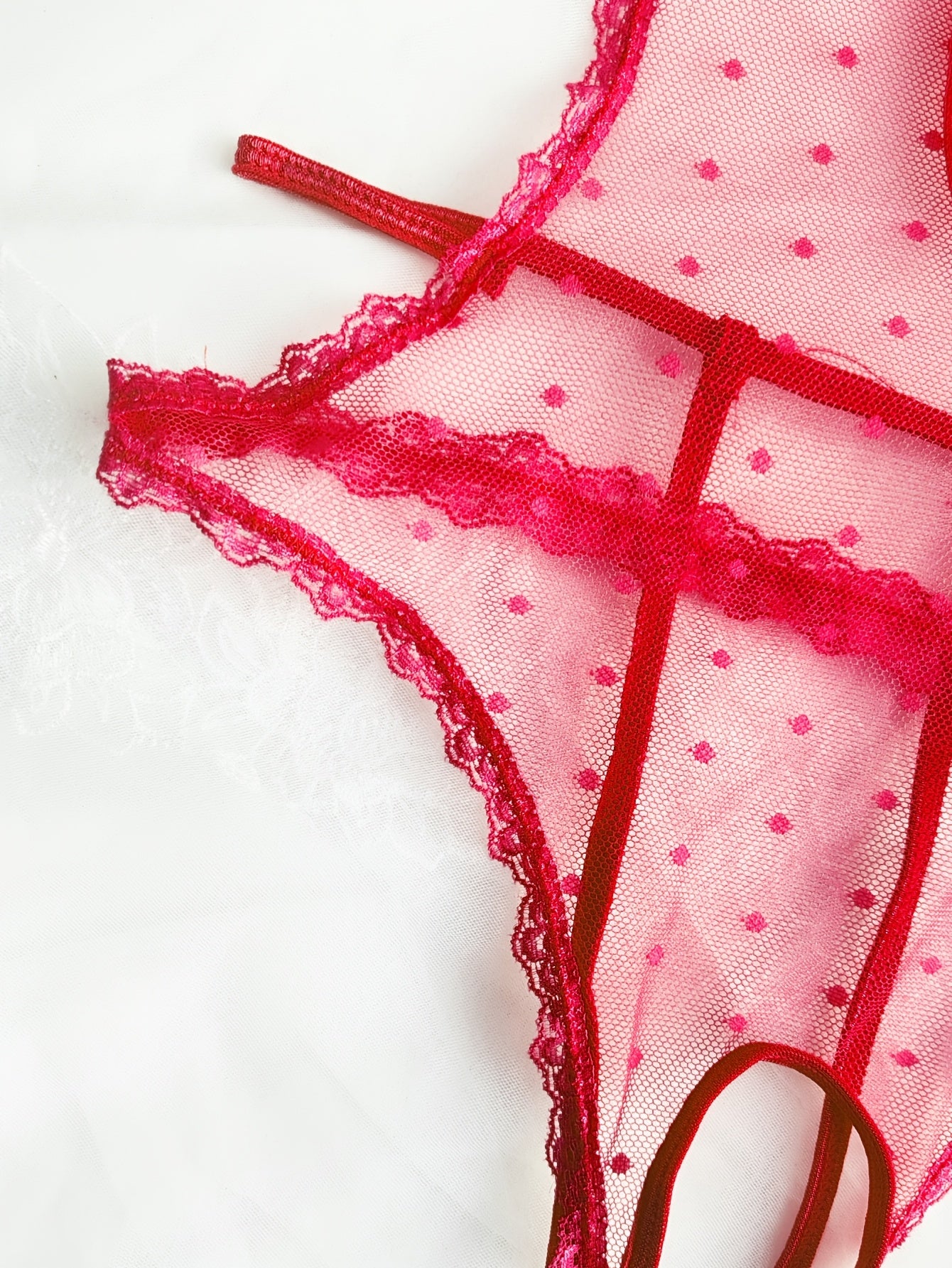 Teshikli, shaffof, old qismida tasma va bog'ich detali bo'lgan dantel patchwork bodysuit.