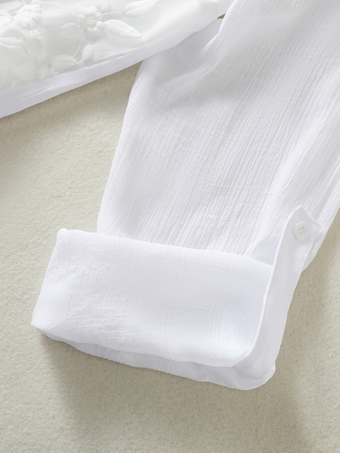 V-yuqori plus o'lchamdagi bluzka, kengaytirilgan pastki qismi va tugma tafsiloti bilan, barcha mavsumlar uchun mos keladigan, cho'zilmaydigan polyester matodan tayyorlangan, bir rangda.