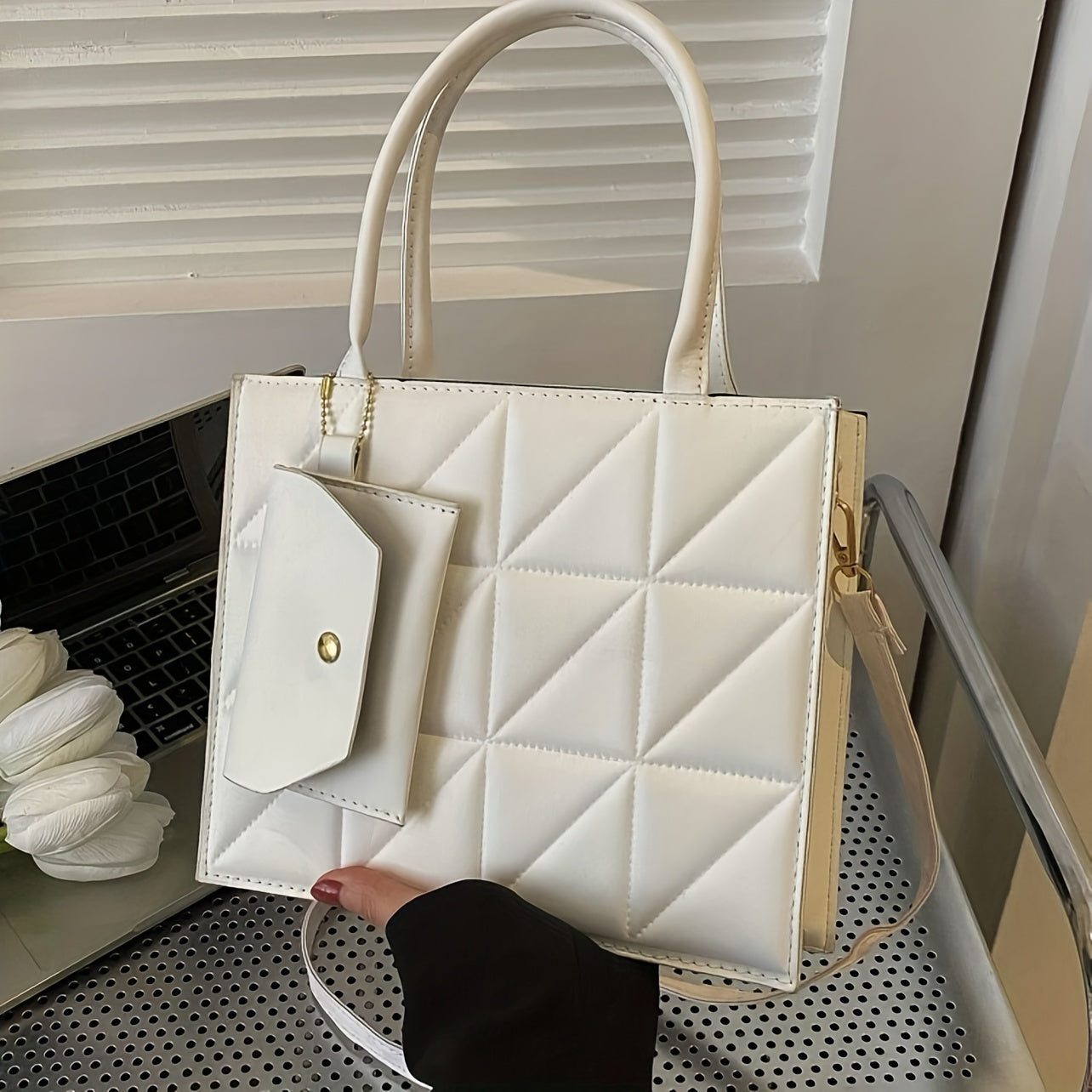 Qora qoplangan sintetik charm sumkasi, oltin detallari va ajraladigan uzun cho‘ntak bilan