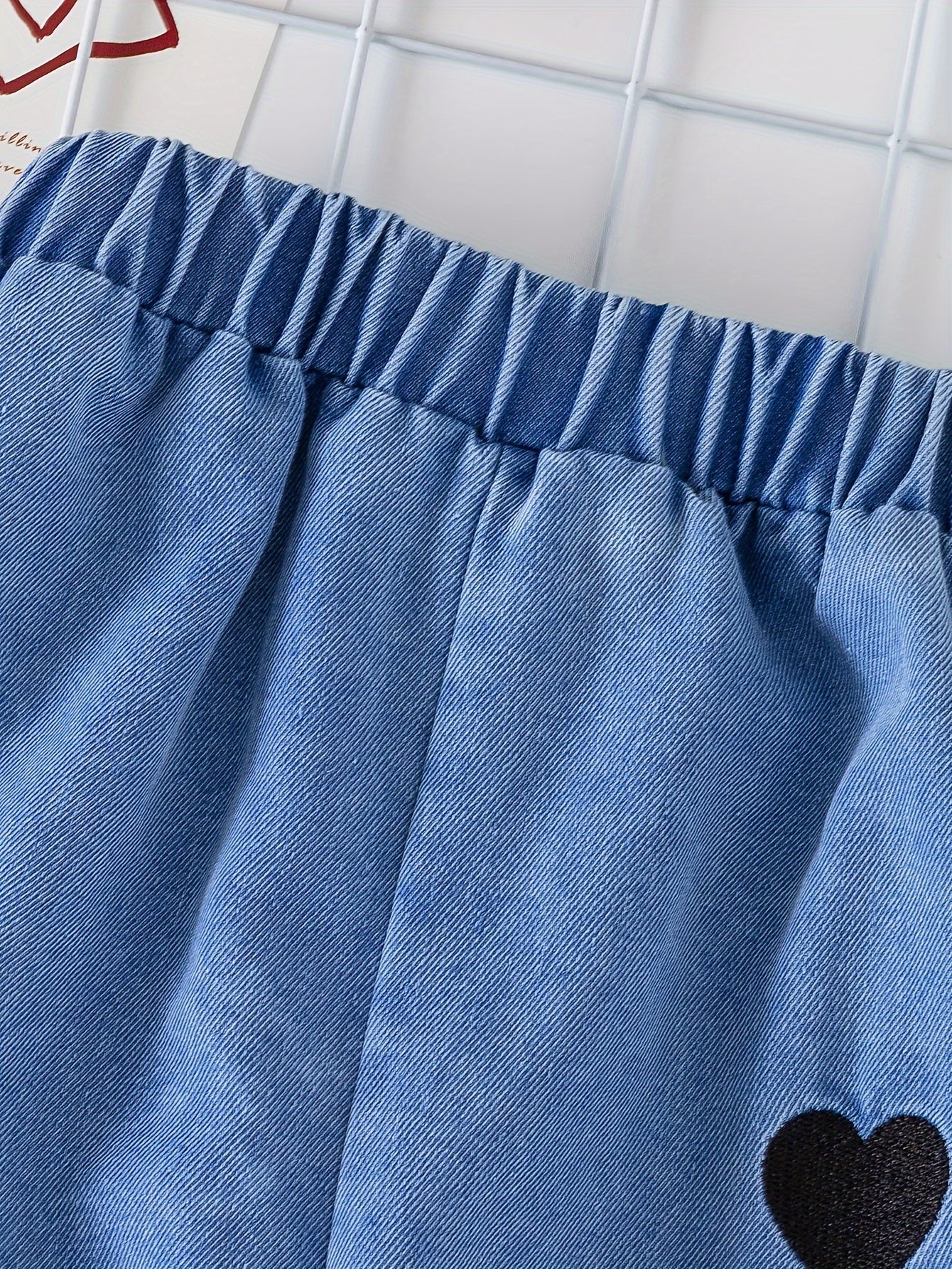 Qizlar uchun yoqimli to'plam, yurak naqshli yuqori va denim shimlarni o'z ichiga oladi, mashinada yuvish mumkin, ochiq havoda kiyish uchun ideal.