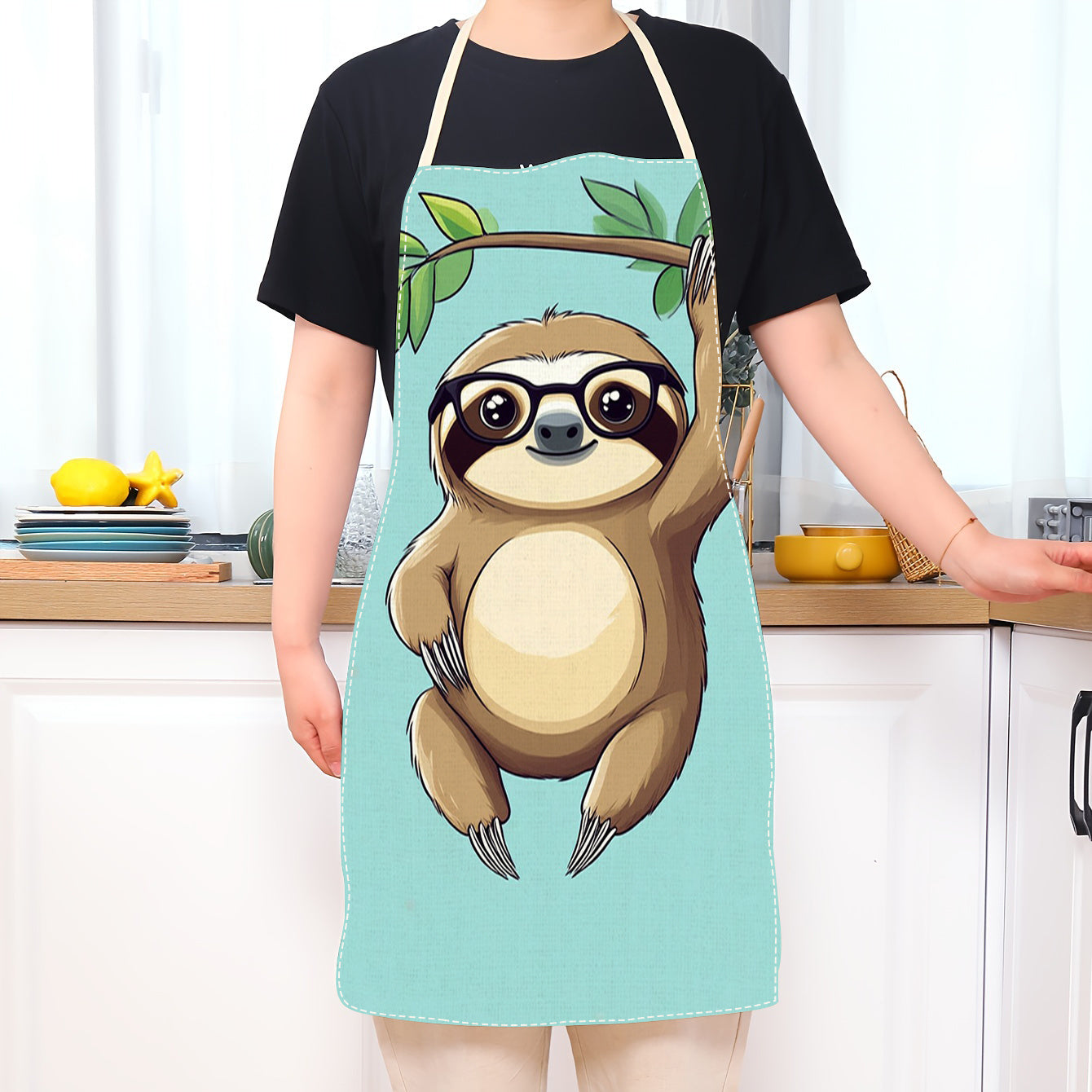 Teal rangli sloth karikaturasi dizayni bilan bezatilgan oshxona oldi. Linozdan tayyorlangan, bu oldi nafas oladigan, suv o'tkazmaydigan va yog'ga chidamli. Uni tozalash oson va pishirish asboblari uchun cho'ntaklari bo'lgan mustahkam matodan tayyorlangan.